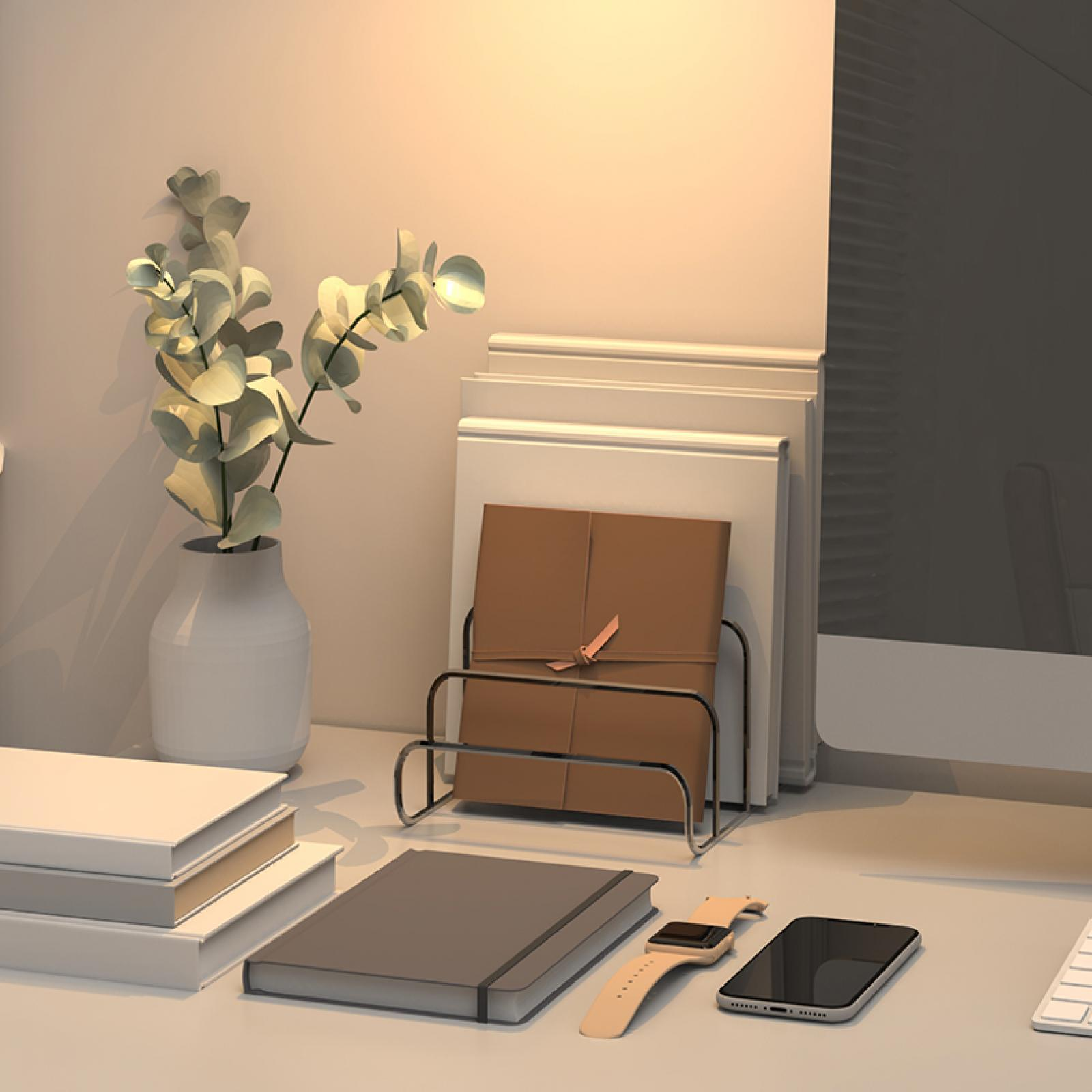 Schreibtisch mit Vase, Büchern, Uhr und Telefon. Brauner Ordner, weißer Monitor und Tastatur ebenfalls vorhanden.