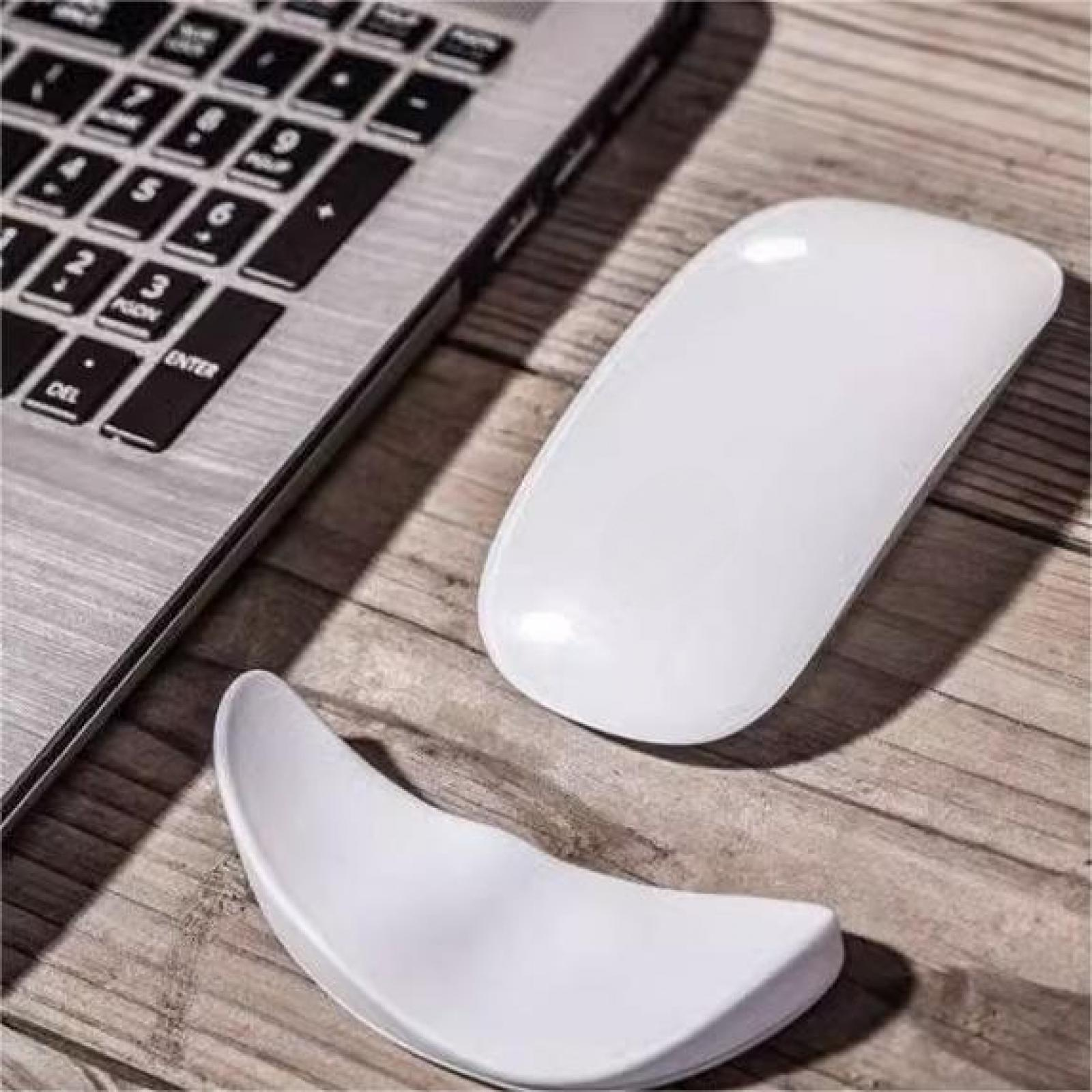 Eine Laptop-Tastatur, eine weiße Maus und ein weißes, gebogenes Mauspad liegen auf einer Holzoberfläche.