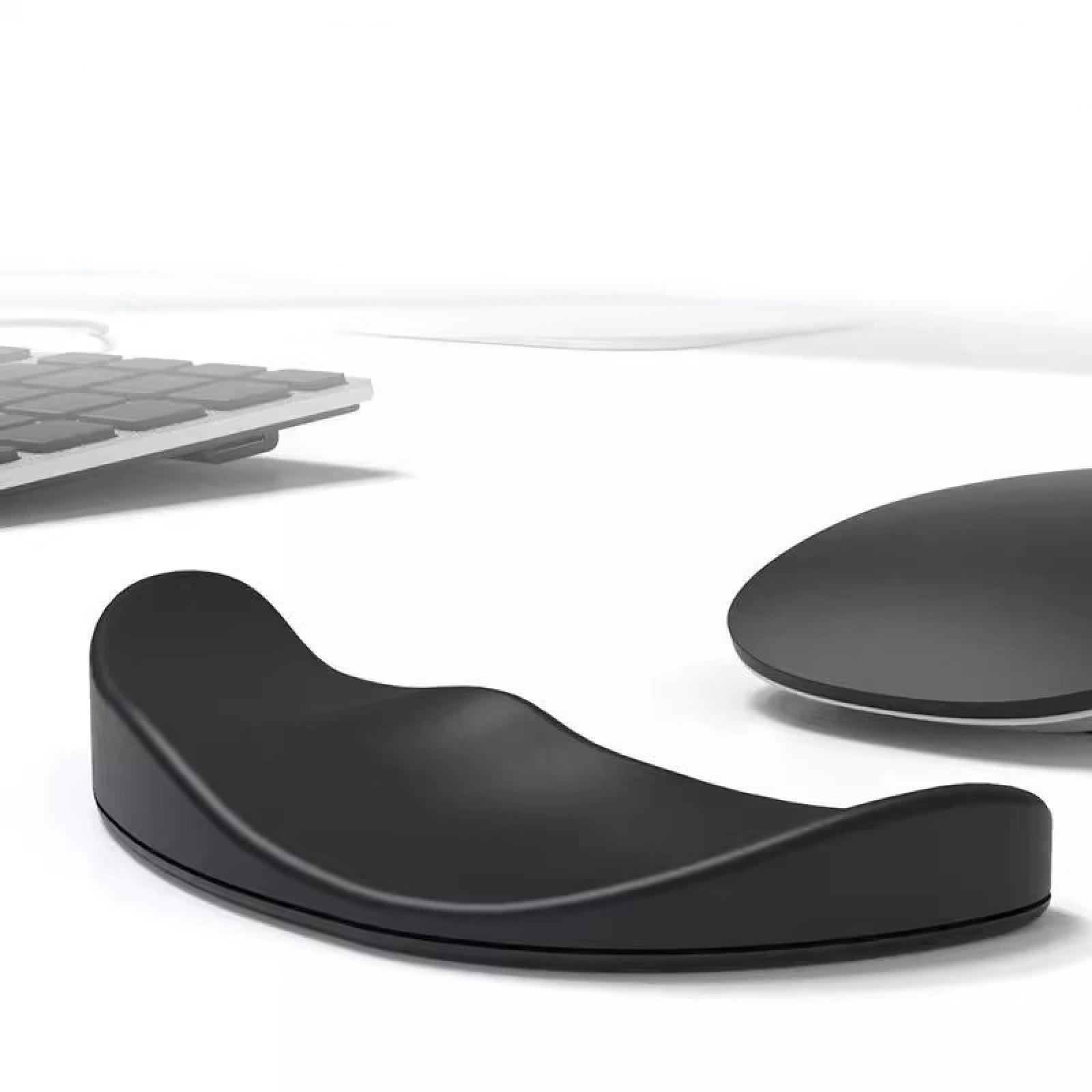 Eine schwarze Handgelenkauflage, eine Maus und eine Tastatur liegen auf einer weißen Oberfläche. Die Auflage ist gebogen.