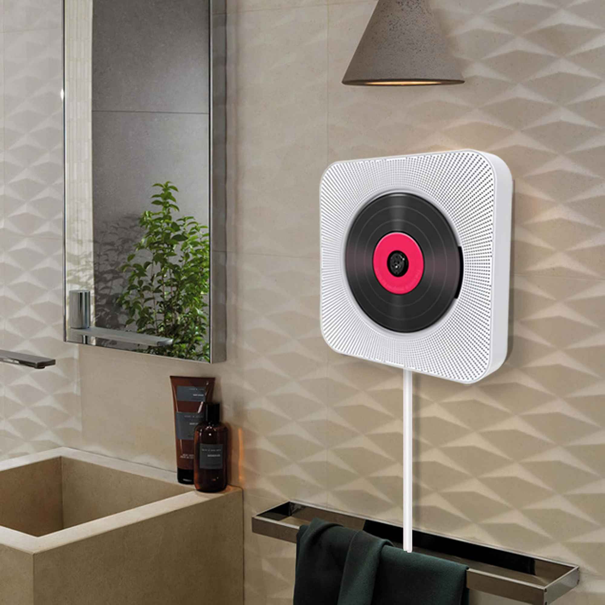 Ein weißer CD-Player mit Vinyl-Design an einer Badezimmerwand. Spiegel und Waschbecken sind sichtbar.