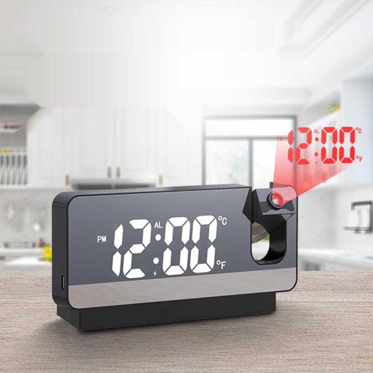 Eine Digitaluhr zeigt 12:00 Uhr an. Die Uhrzeit wird rot projiziert. Sie steht auf einer Holzoberfläche, mit Küchenhintergrund.