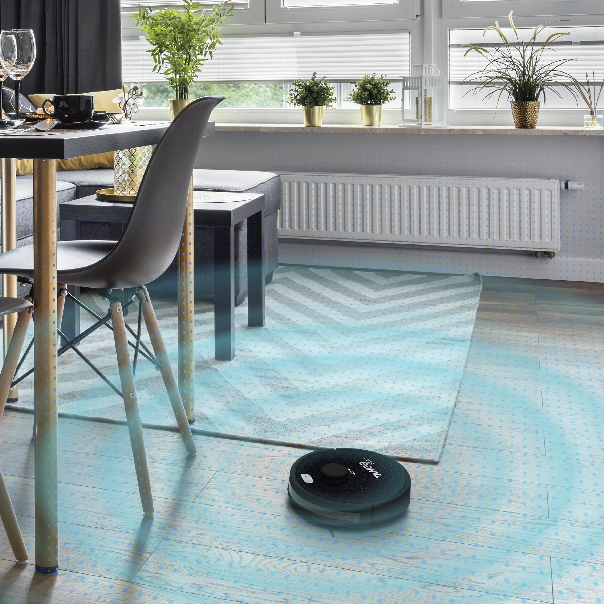 Nowoczesny salon z stołem jadalnym, robotem sprzątającym i oknem.