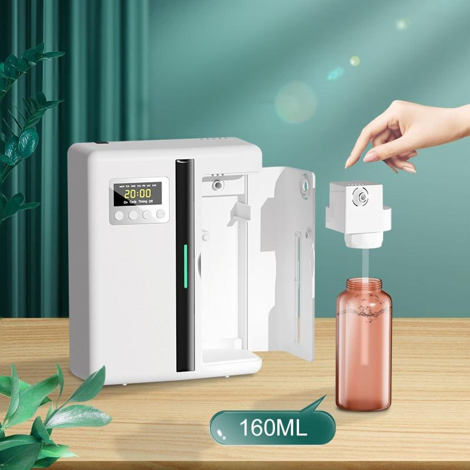 Ein weißer Lufterfrischer mit Digitalanzeige, neben einer Flasche und einer Hand. Es steht auf einem Holztisch.