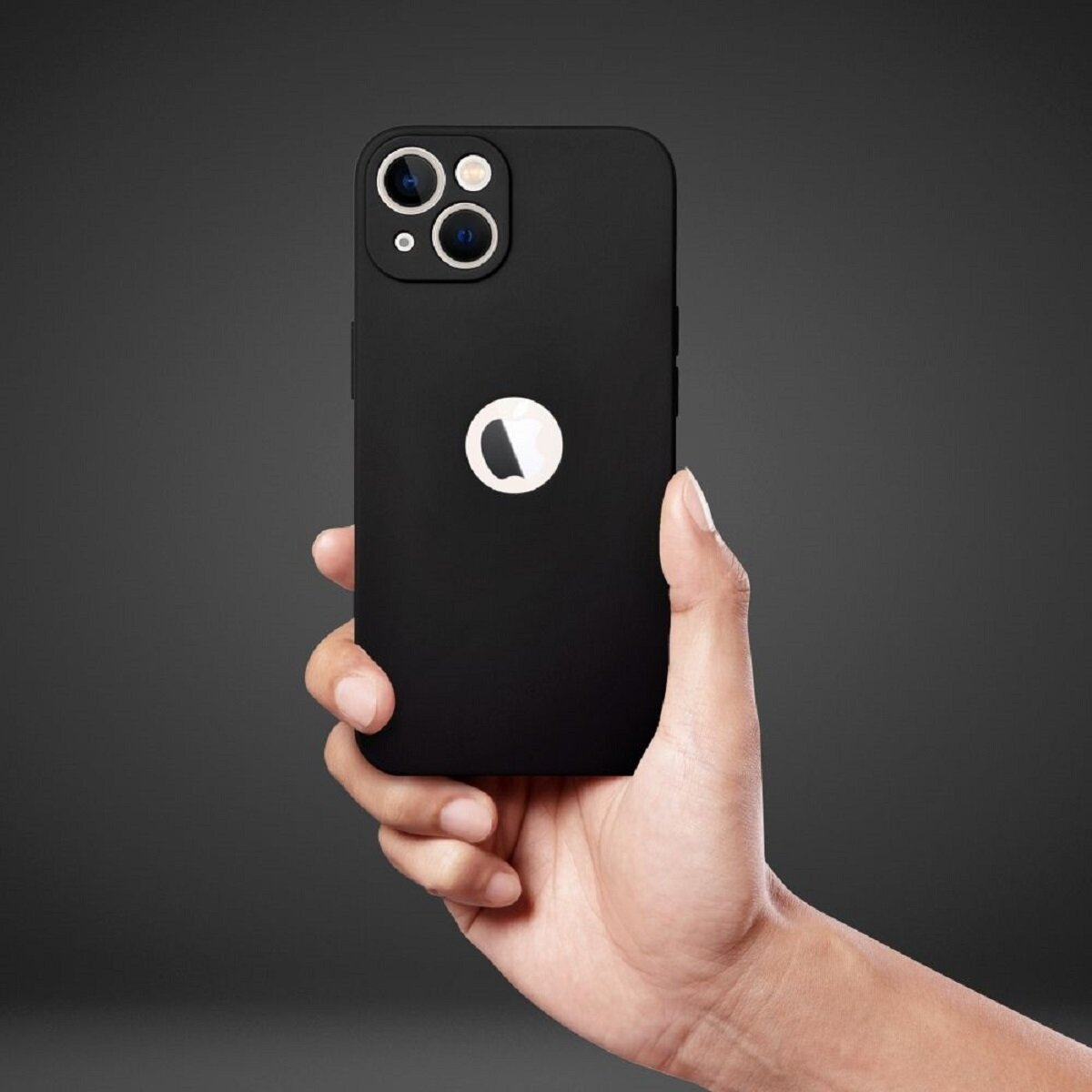 Eine Hand, die ein schwarzes iPhone mit weißem Logo hält. Das Telefon hat eine Kameraausbuchtung mit drei Objektiven. Der Hintergrund ist dunkelgrau.