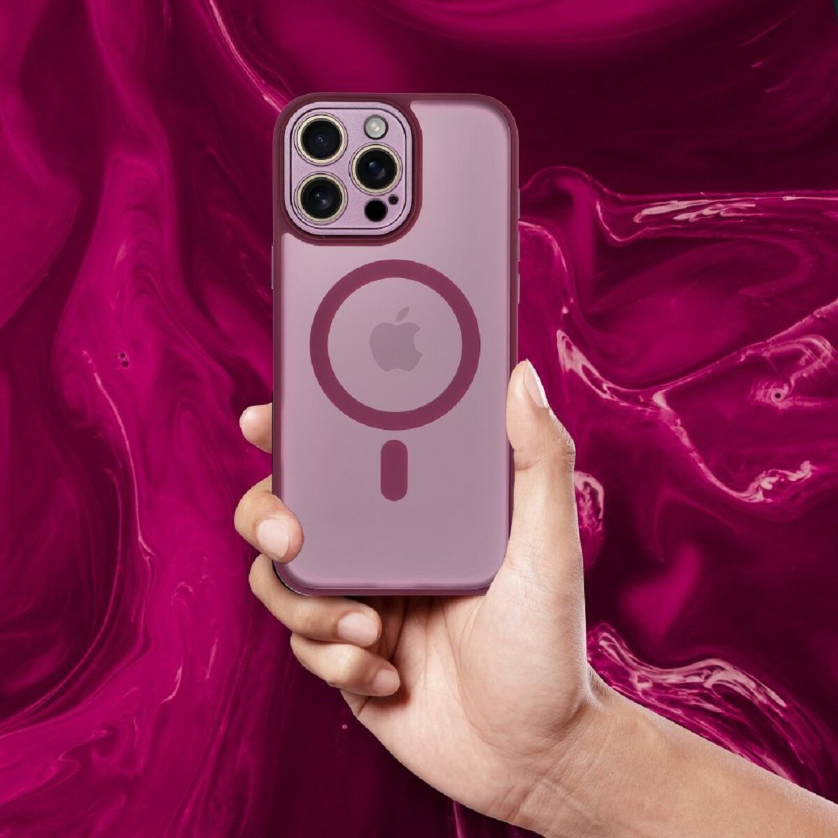 Eine Hand hält ein lila iPhone mit Hülle. Der Hintergrund ist ein wirbelndes magenta Muster.