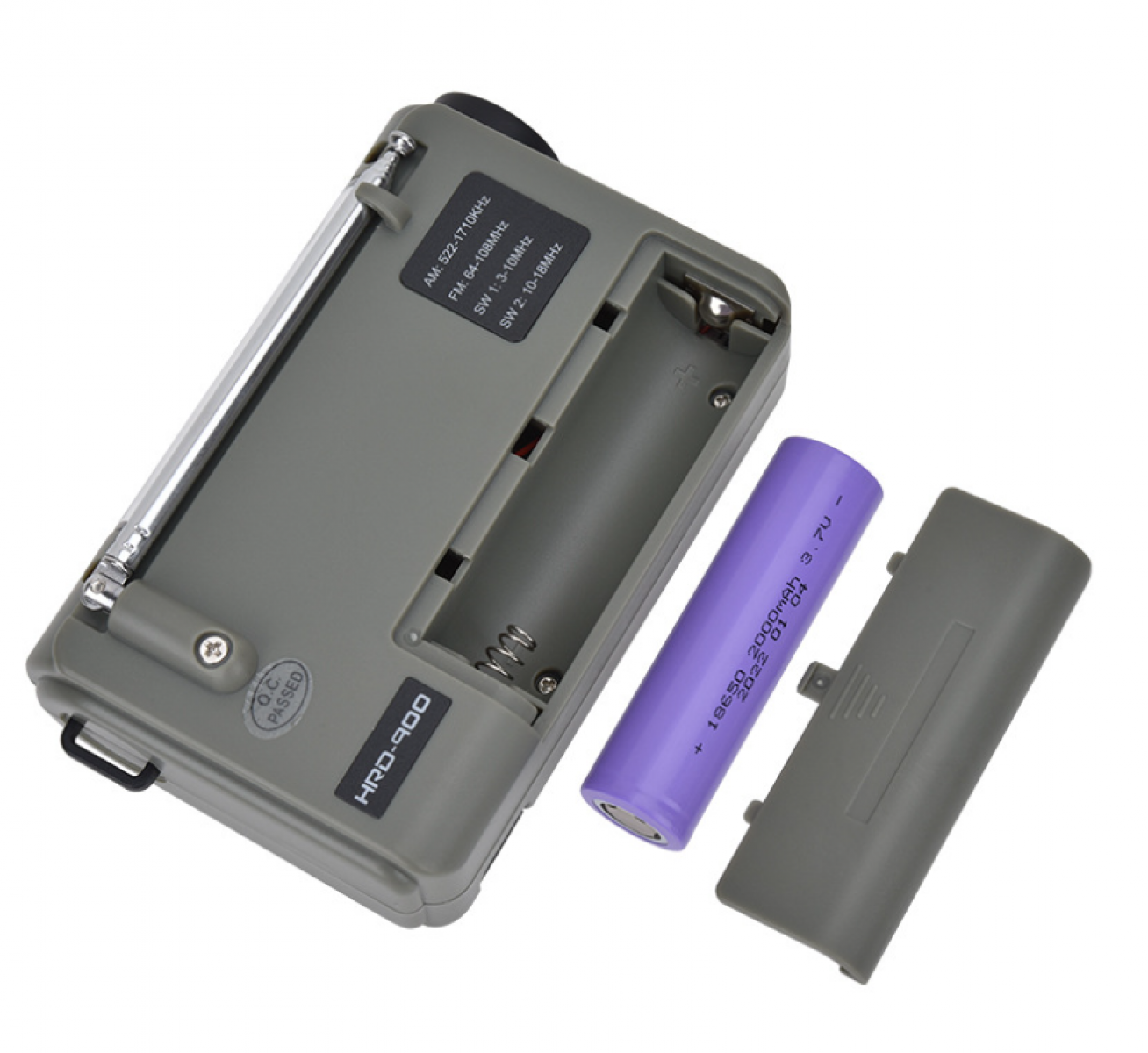 Ein graues Radio mit offenem Batteriefach, einer lila Batterie und einer abgenommenen grauen Abdeckung. Das Radio hat eine ausziehbare Antenne.