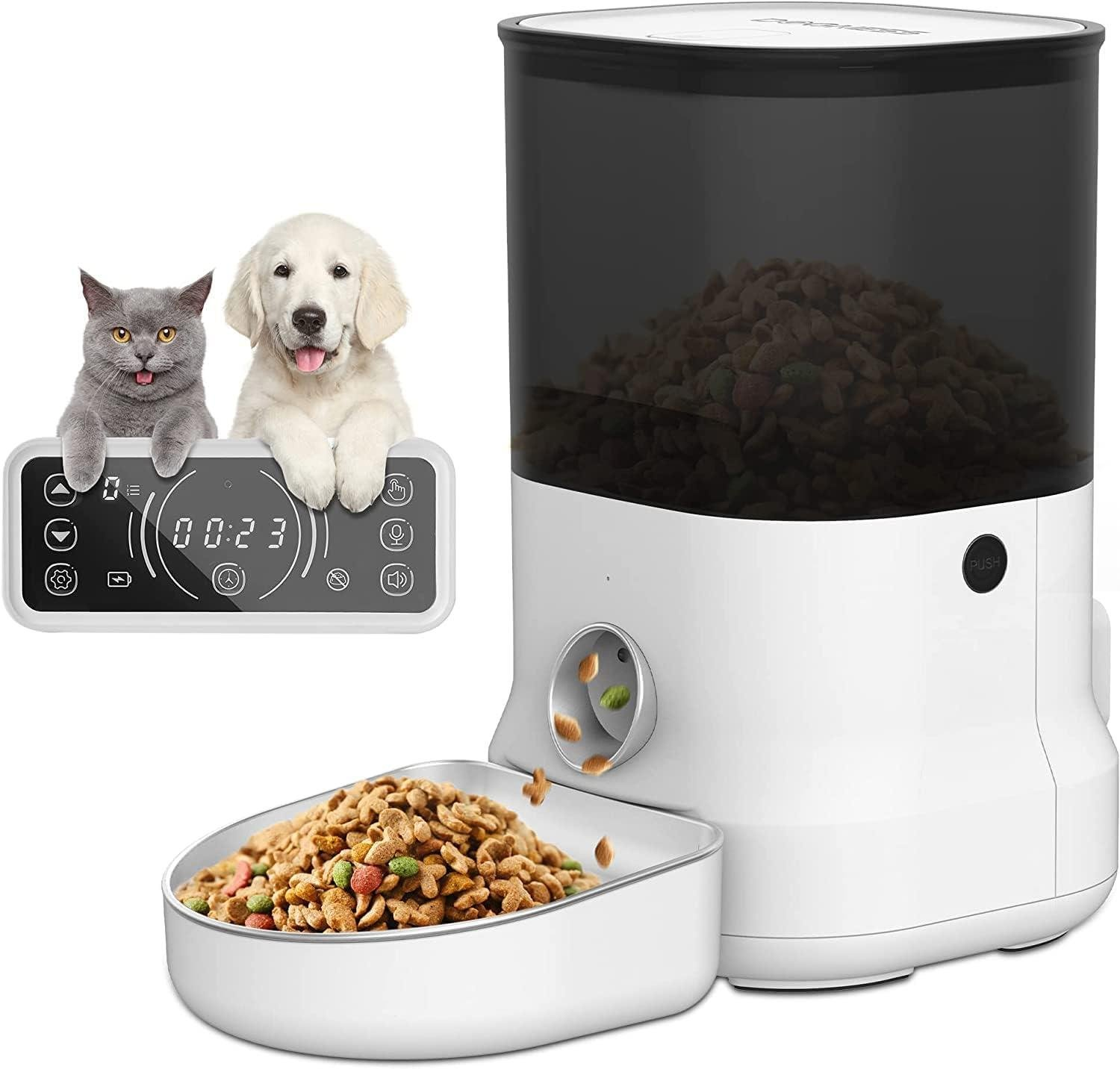 Dijital bir besleyici yanında bir kedi ve bir köpek yavrusu, kaseye mama dağıtıyor. Besleyici beyaz ve siyahtır.