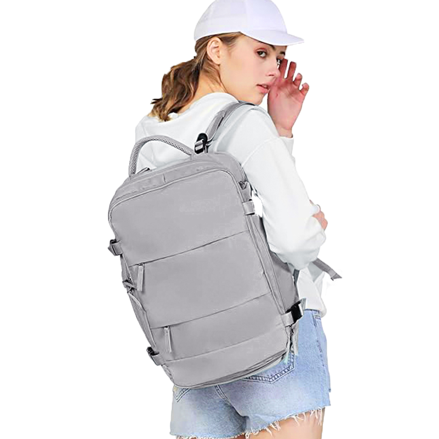 Una donna con berretto bianco e zaino, che guarda indietro. Indossa una camicia bianca e pantaloncini di jeans.