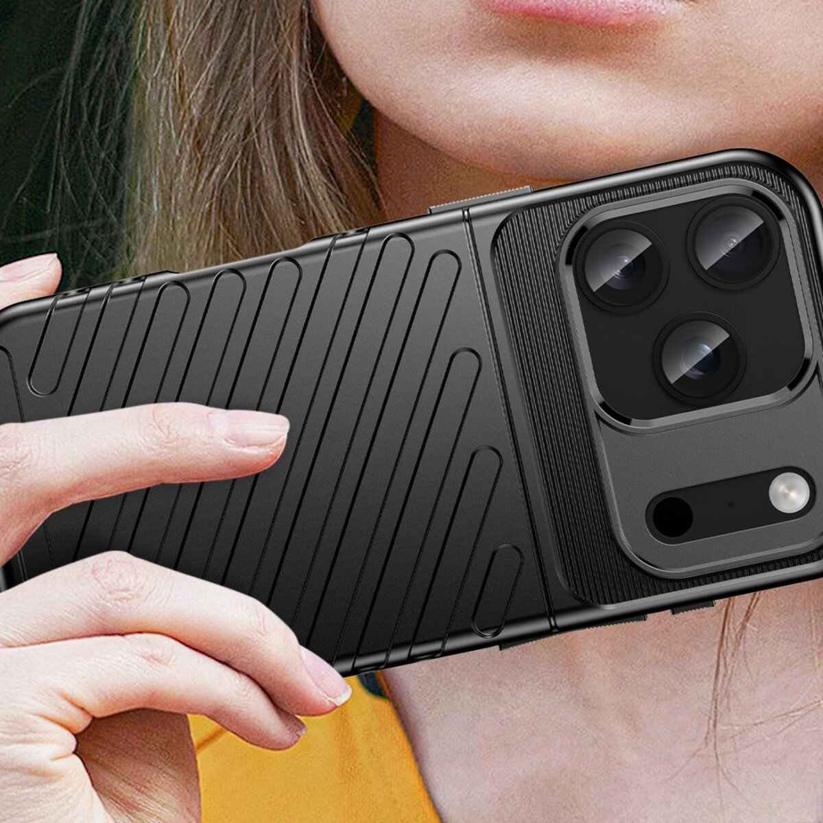 Eine Person hält eine schwarze Handyhülle mit Kameramodul. Die Hülle hat eine strukturierte Oberfläche mit diagonalen Linien. Eine Hand ist sichtbar.