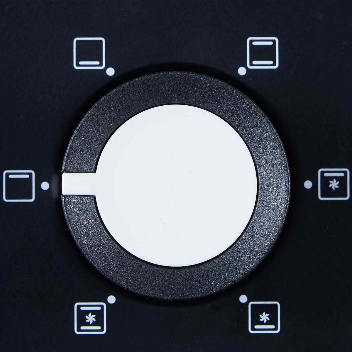 Zbliżenie czarnego panelu sterowania piekarnika z centralnym białym pokrętłem. Ikony piekarnika i rozmrażania otaczają pokrętło.