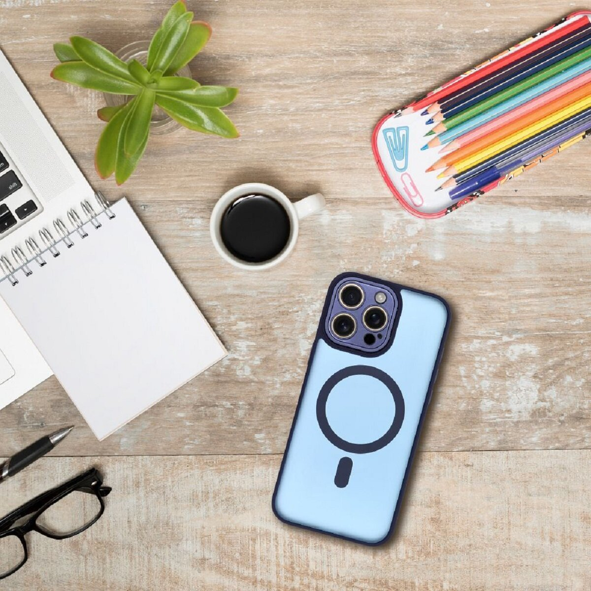 Ein Schreibtisch mit Laptop, Notizbuch, Kaffee, Telefon, Bleistiften, Brille und Pflanze. Farben: Holz, Grün, Blau, Schwarz und Weiß.