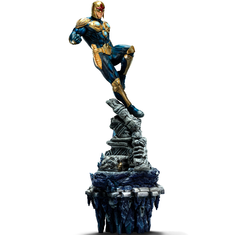 Una figura di supereroe in un costume blu e oro è appollaiata su una struttura rocciosa. La figura è in posa dinamica su sfondo bianco.