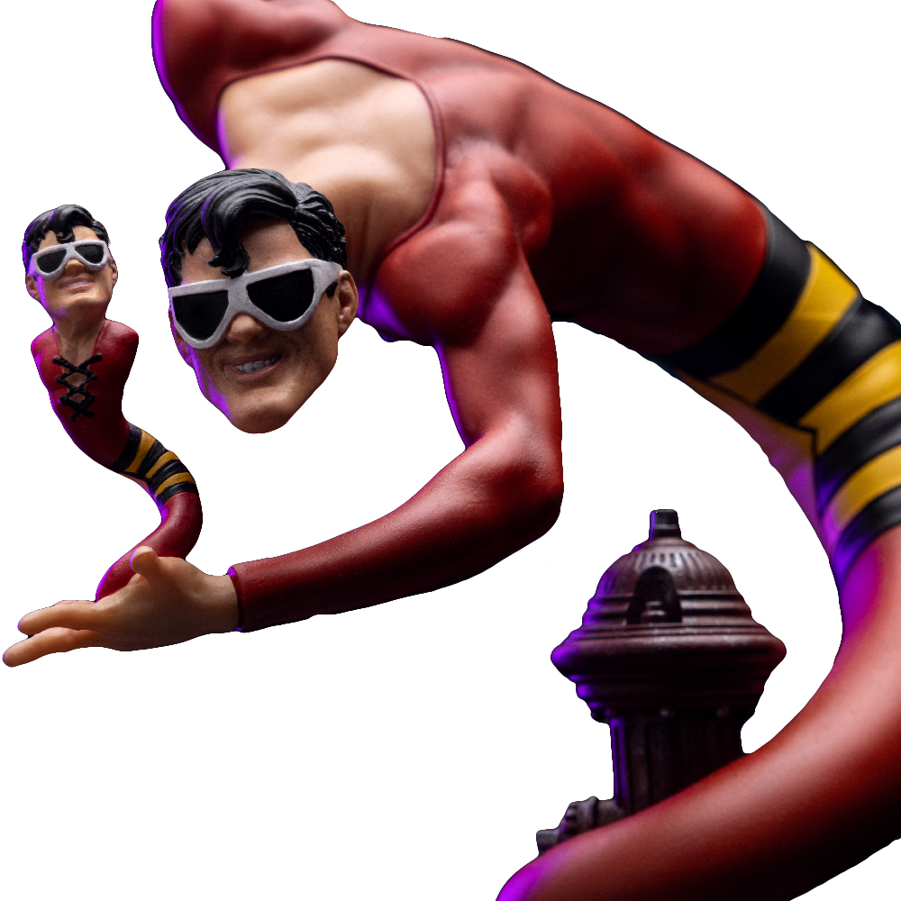 Una statuetta di Plastic Man in tuta rossa con strisce nere e gialle. Indossa occhiali da sole. Un idrante marrone sullo sfondo.