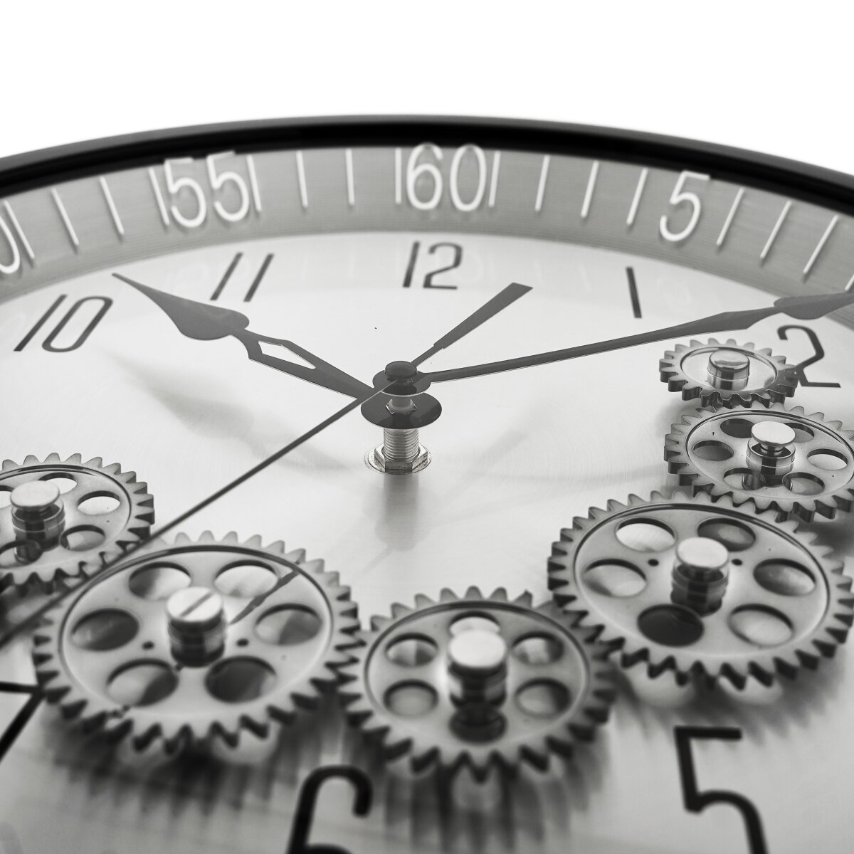 Nahaufnahme einer Uhr mit Zahnrädern. Schwarze Zeiger zeigen auf 11:06 Uhr. Silberne Zahnräder sind sichtbar. Zahlen 10, 11, 12, 1, 2 und 5 werden angezeigt.