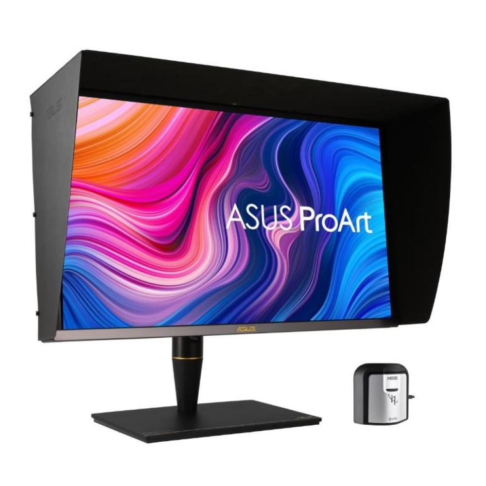 Un monitor ASUS ProArt con capota negra muestra arte abstracto colorido. A la derecha hay un pequeño dispositivo.
