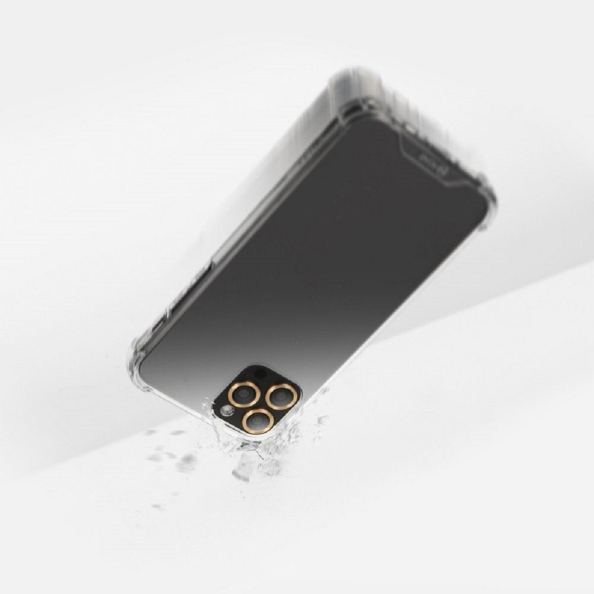 Ein Telefon in einer transparenten Hülle fällt, die Kameralinsen sind sichtbar. Trümmer deuten auf einen Aufprall auf einer weißen Oberfläche hin.