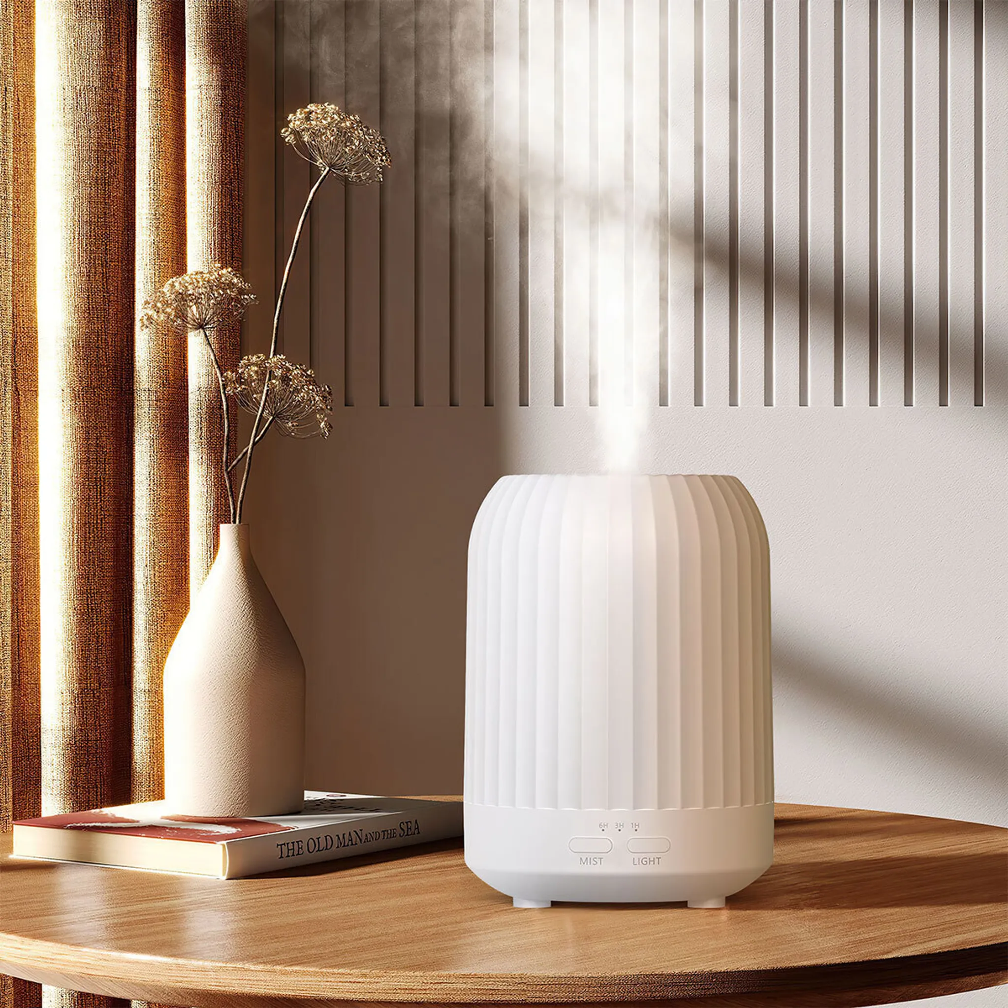 Weißer Diffusor emittiert Dampf auf einem Holztisch. Links eine Vase mit Trockenblumen. Hintergrund hat vertikale Linien.