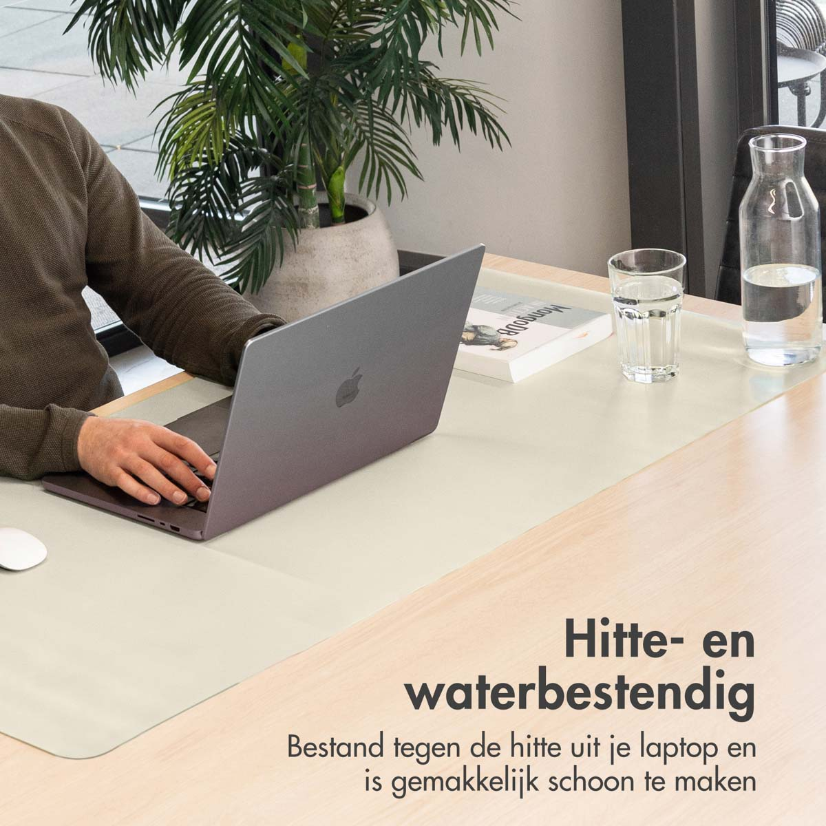 A person using a laptop on a desk. There's a plant, water glass, and book. Text says: Heat and water resistant.