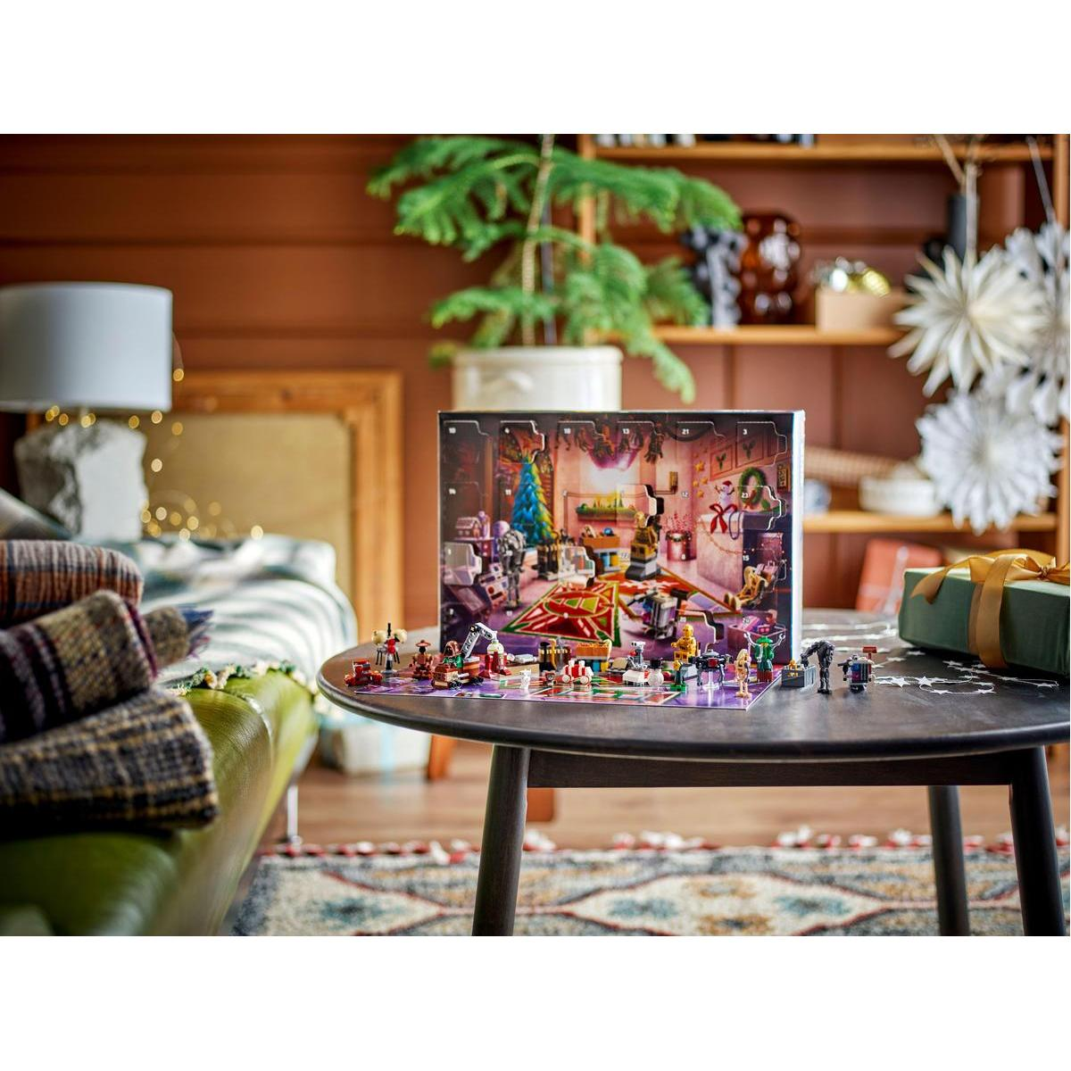 Una mesa redonda muestra un calendario de Adviento de Lego y figuras. Un árbol de Navidad está en el calendario. Hay una caja de regalo a la derecha.