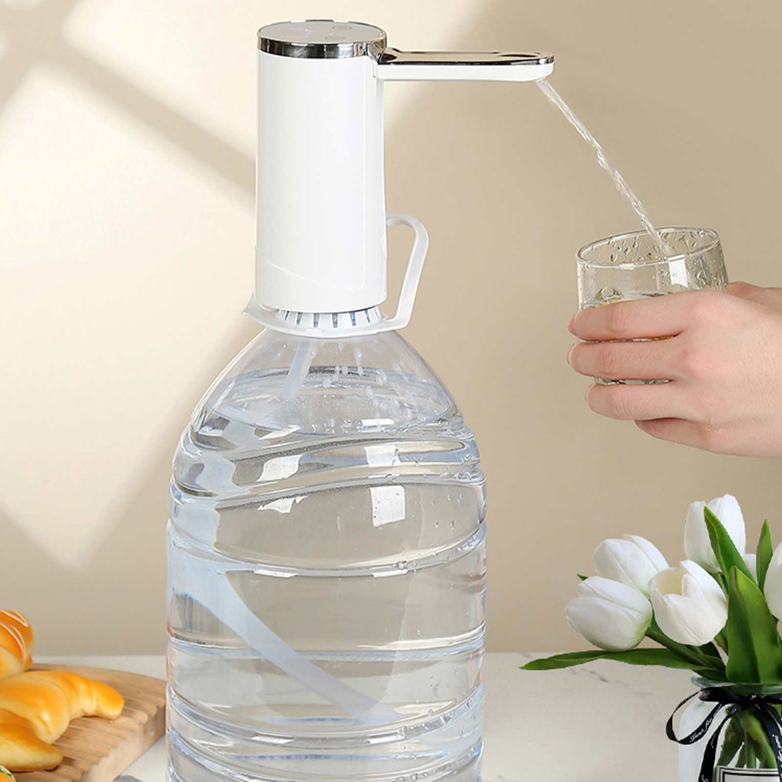 Ein weißer Wasserspender auf einer großen Wasserflasche gießt Wasser in ein Glas. Blumen sind im Hintergrund.