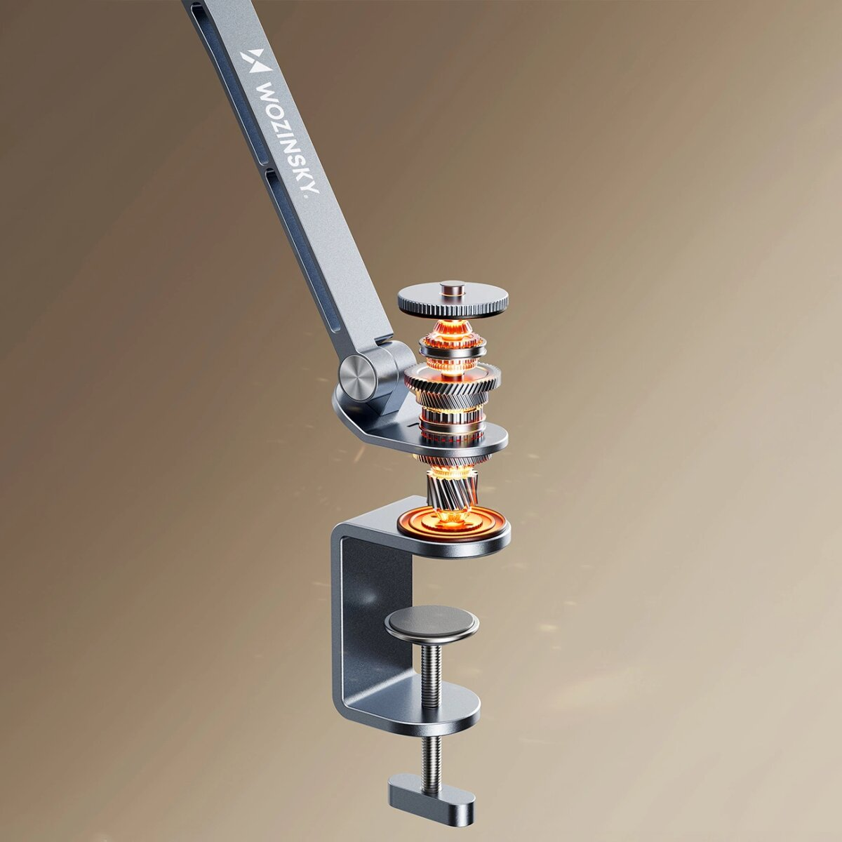 Een metalen bureaubevestigingsarm met het merk 'WOZINSKY'. De arm heeft zichtbare tandwielen met oranje verlichting, tegen een bruine achtergrond.