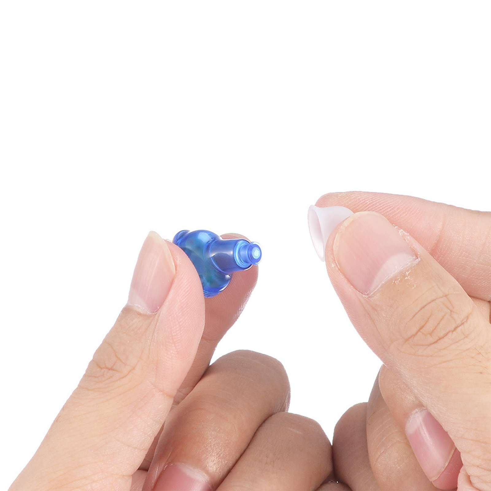 Hände halten ein blaues Hörgerät und einen weißen Ohrstöpsel vor weißem Hintergrund.