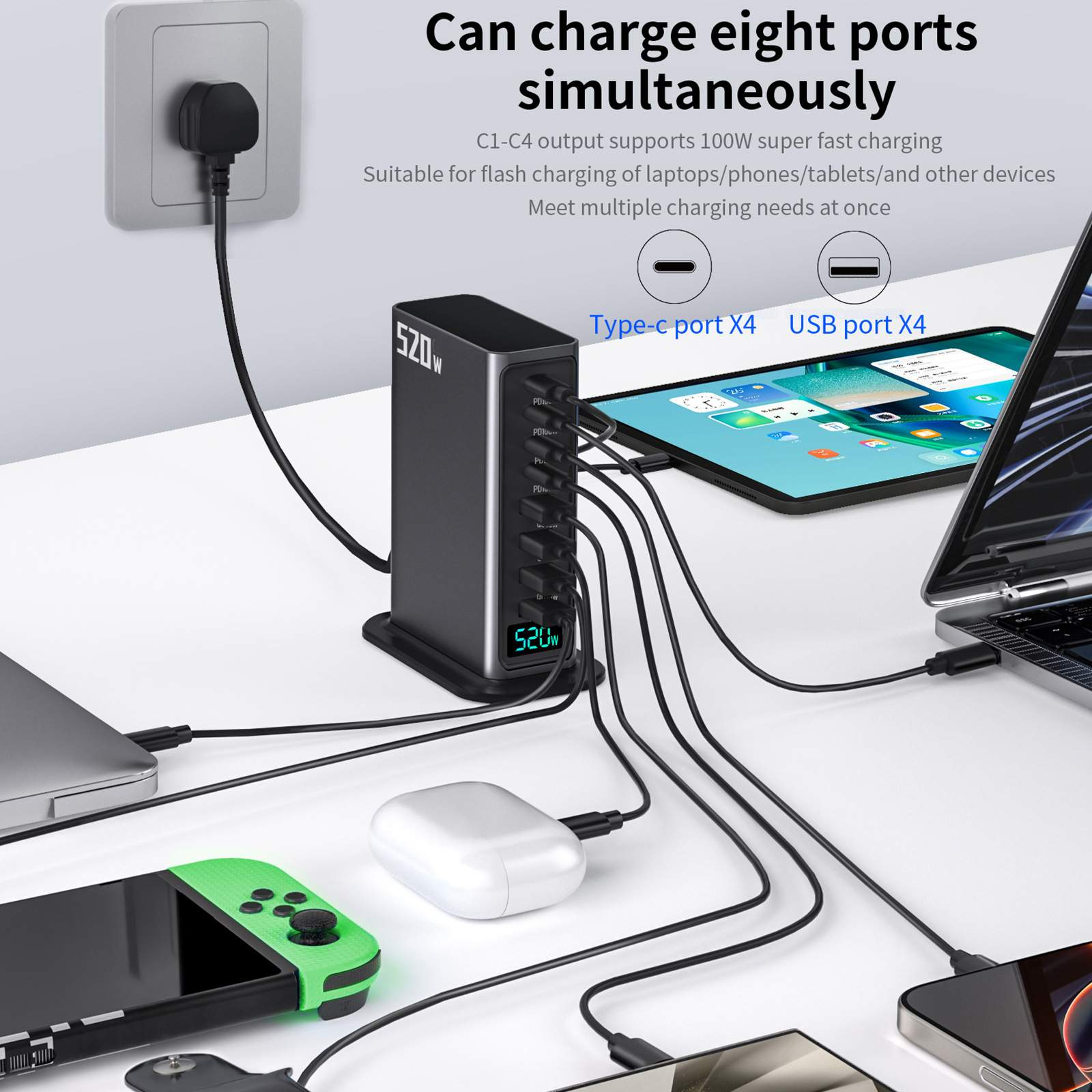 Eine schwarze Ladestation versorgt mehrere Geräte mit Strom, darunter ein Laptop, ein Tablet, ein Telefon und ein Switch. Ein Stecker steckt in der Wand.