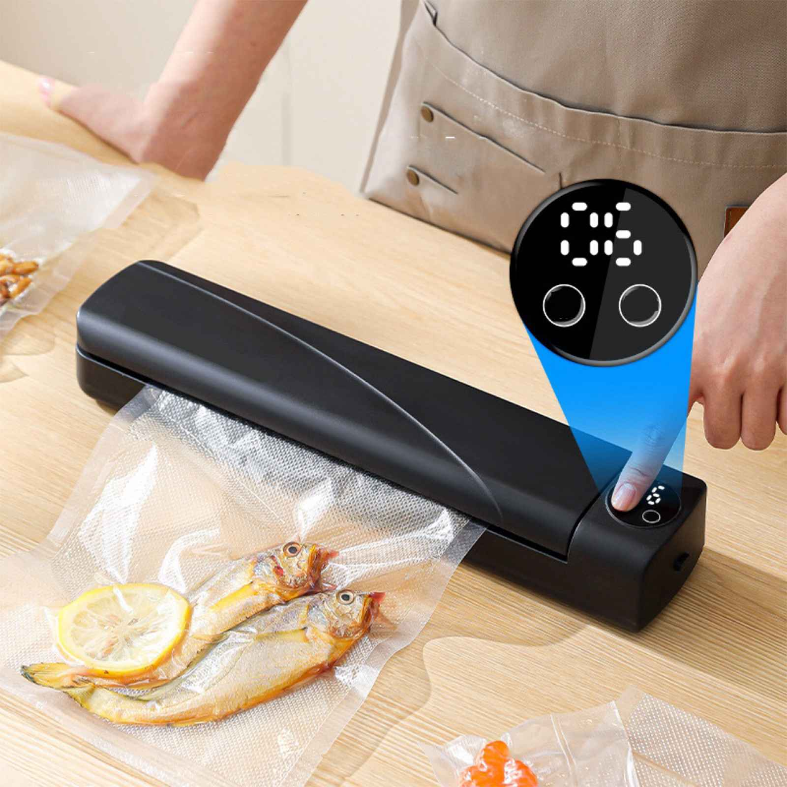 Ein Lebensmittelversiegeler mit Fisch und Zitrone. Ein Finger drückt auf die Taste. Digitalanzeige ist an.