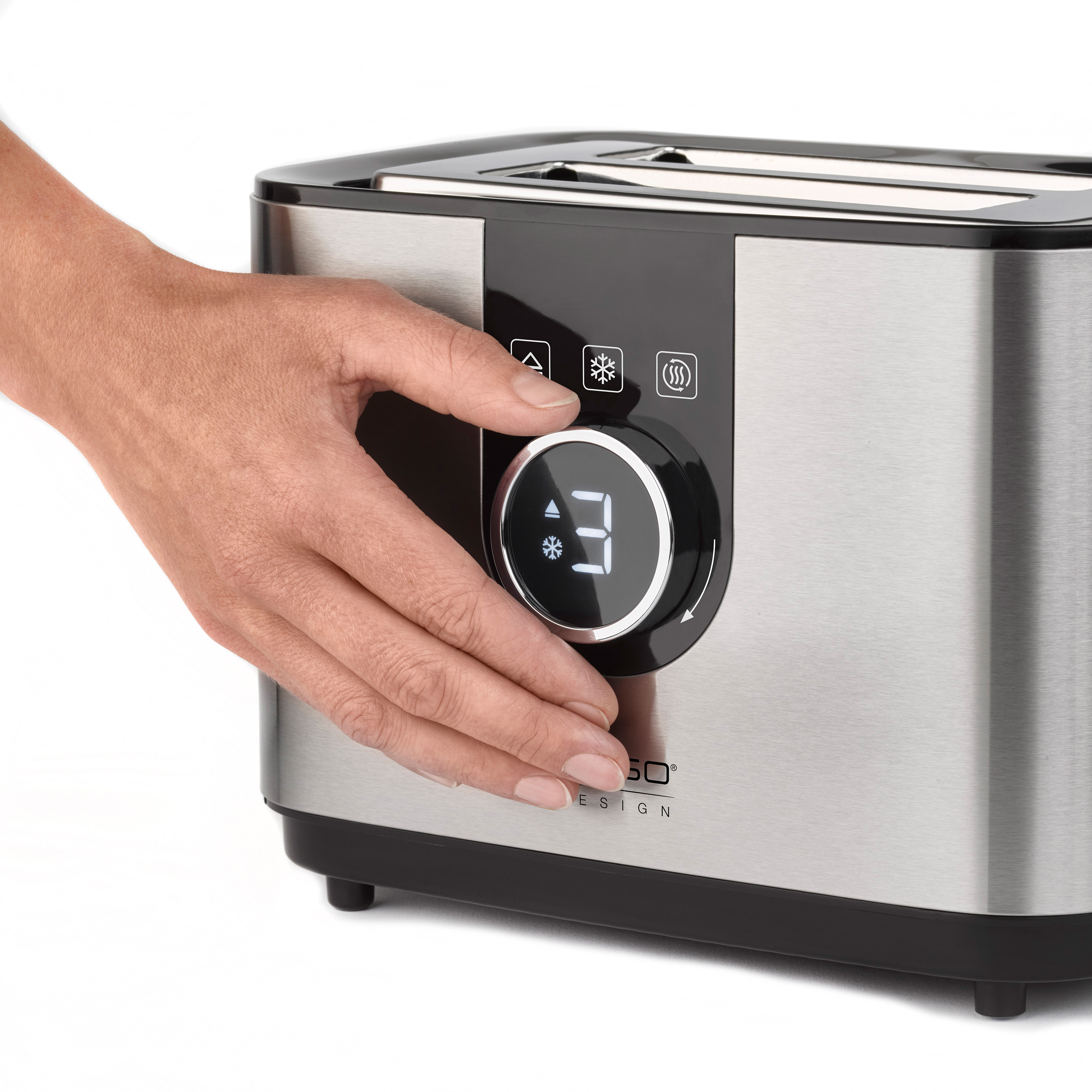 Eine Hand dreht einen Drehregler an einem Toaster aus Edelstahl. Der Drehregler ist schwarz mit weißen Zahlen.