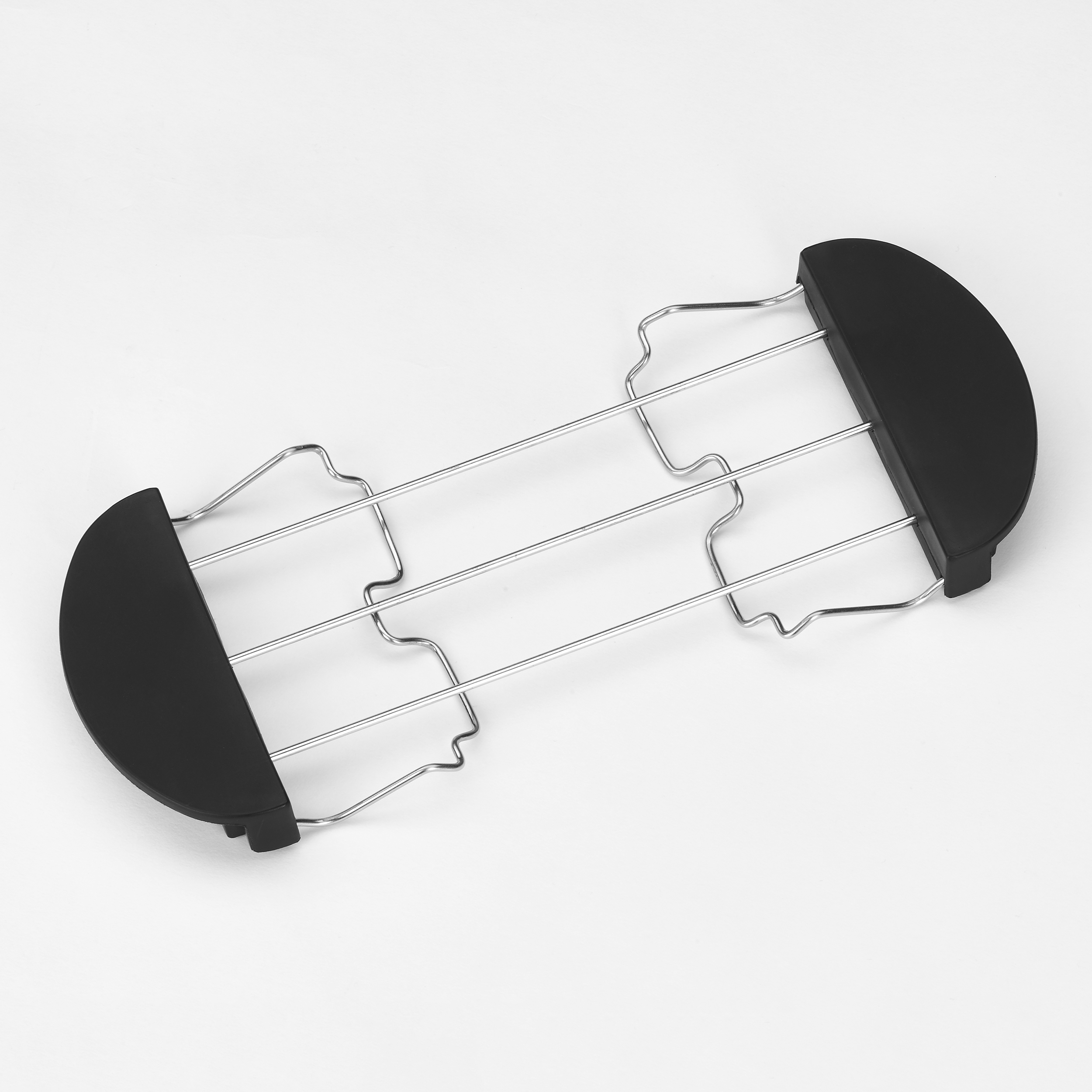 Ein Toaster-Rack aus Metall und Schwarz liegt auf einer weißen Oberfläche. Das Rack hat eine gebogene Form.