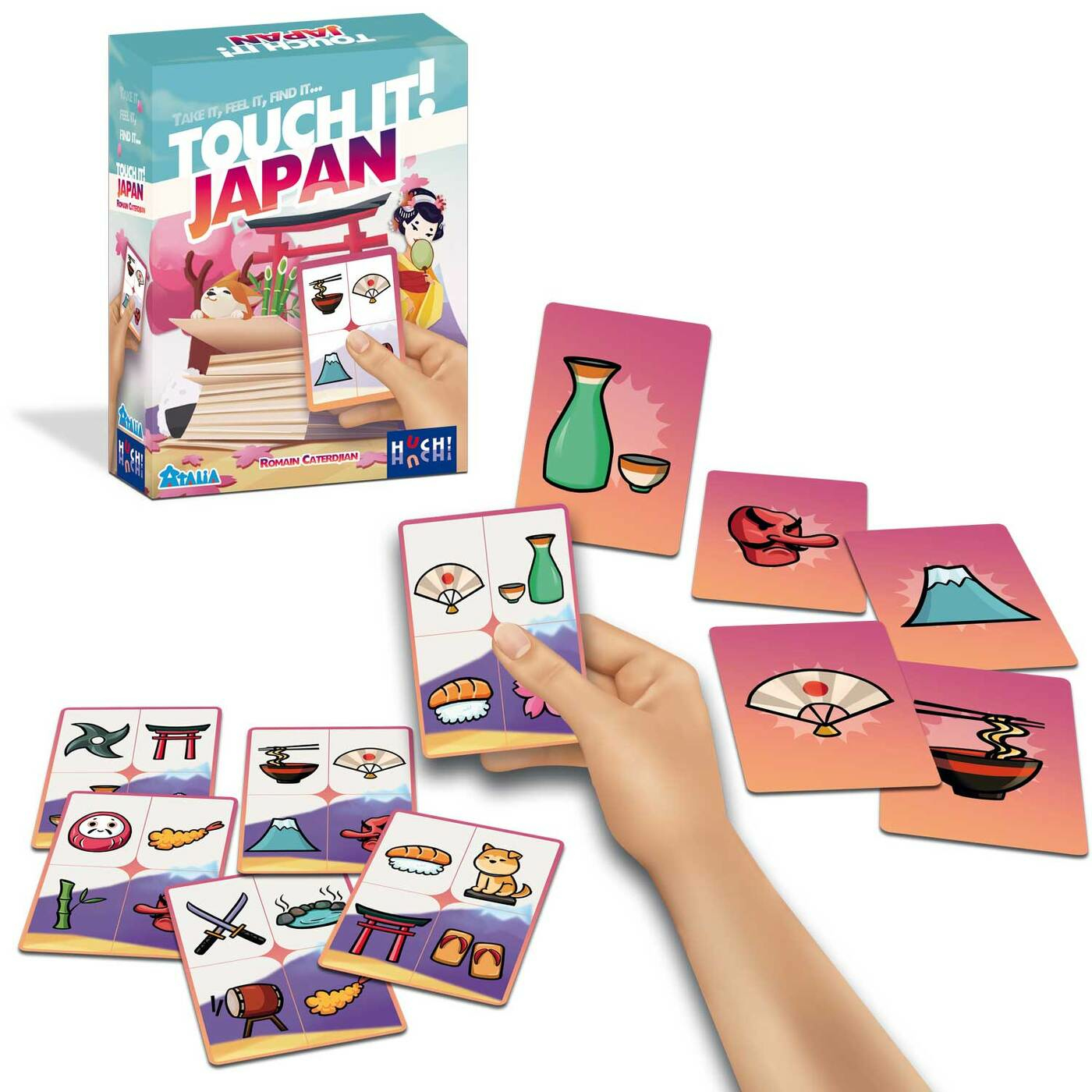 Eine Hand hält Karten aus dem Spiel Touch It! Japan. Karten zeigen japanische Symbole. Die Spielbox ist im Hintergrund.
