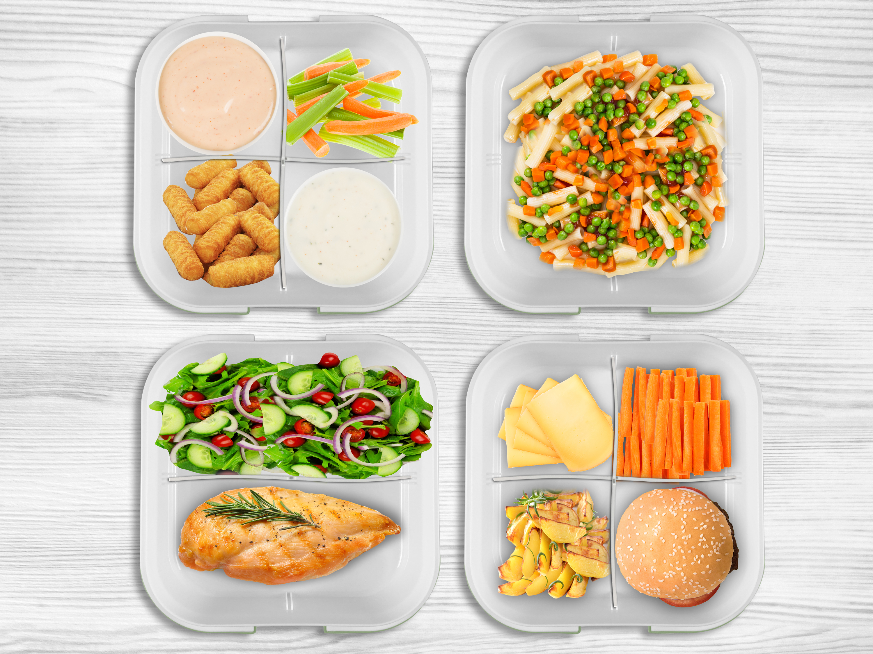 Quattro portapranzo con pasti diversi, tra cui pasta, insalata, pollo, hamburger, verdure e salse.