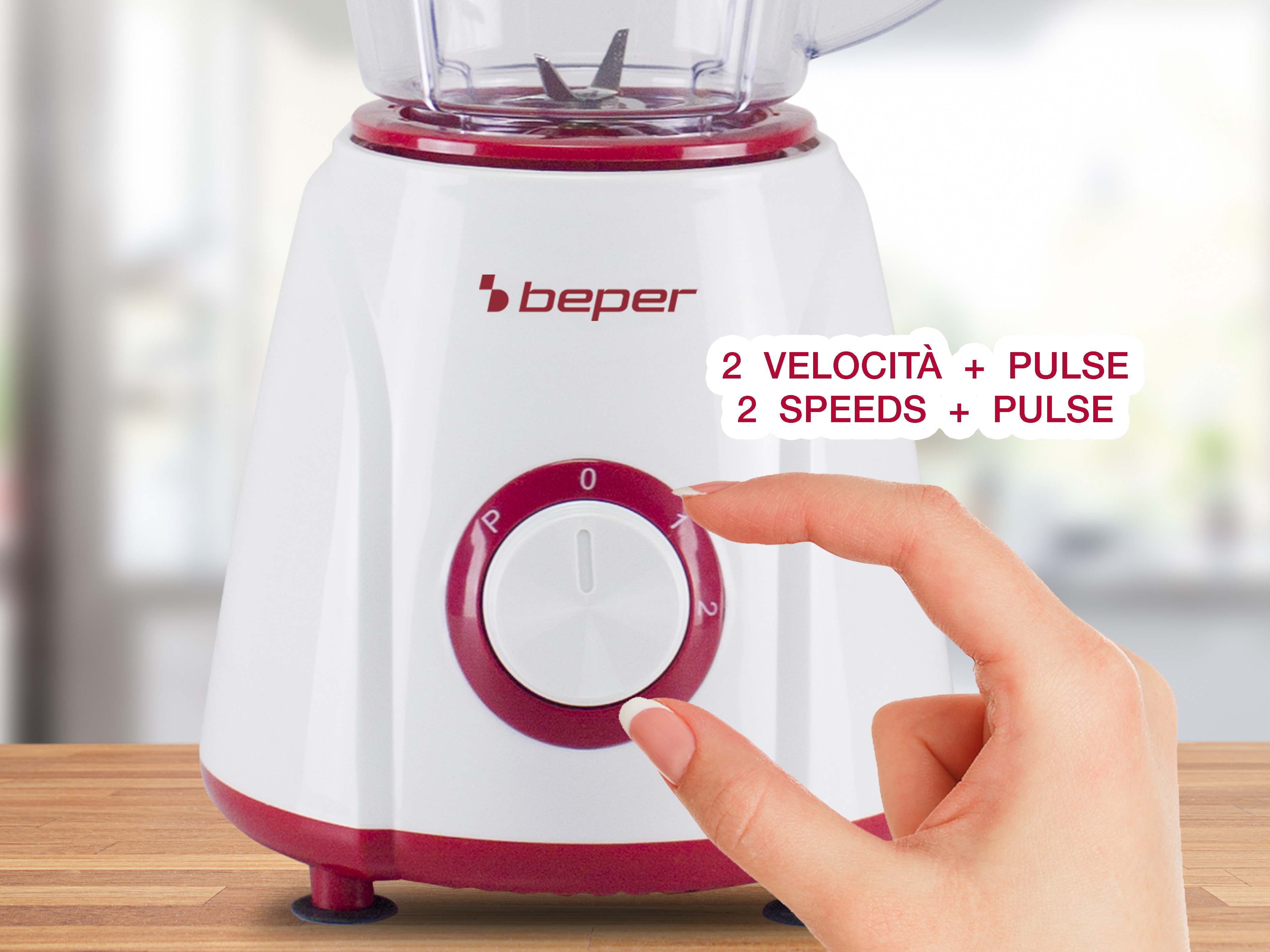Un frullatore bianco e rosso. Una mano gira il quadrante. Il testo dice '2 velocità + impulso'.