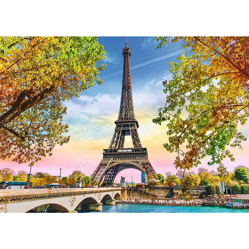 Tour Eiffel à Paris, France. Un pont et une rivière au premier plan, des arbres aux feuilles colorées encadrent la tour.