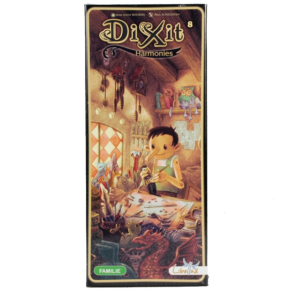 Das Dixit Harmonies-Box-Art zeigt eine Pinocchio-ähnliche Figur, die eine Puppe bastelt. Der Hintergrund hat Werkzeuge, Bücher und fantastische Kreaturen.