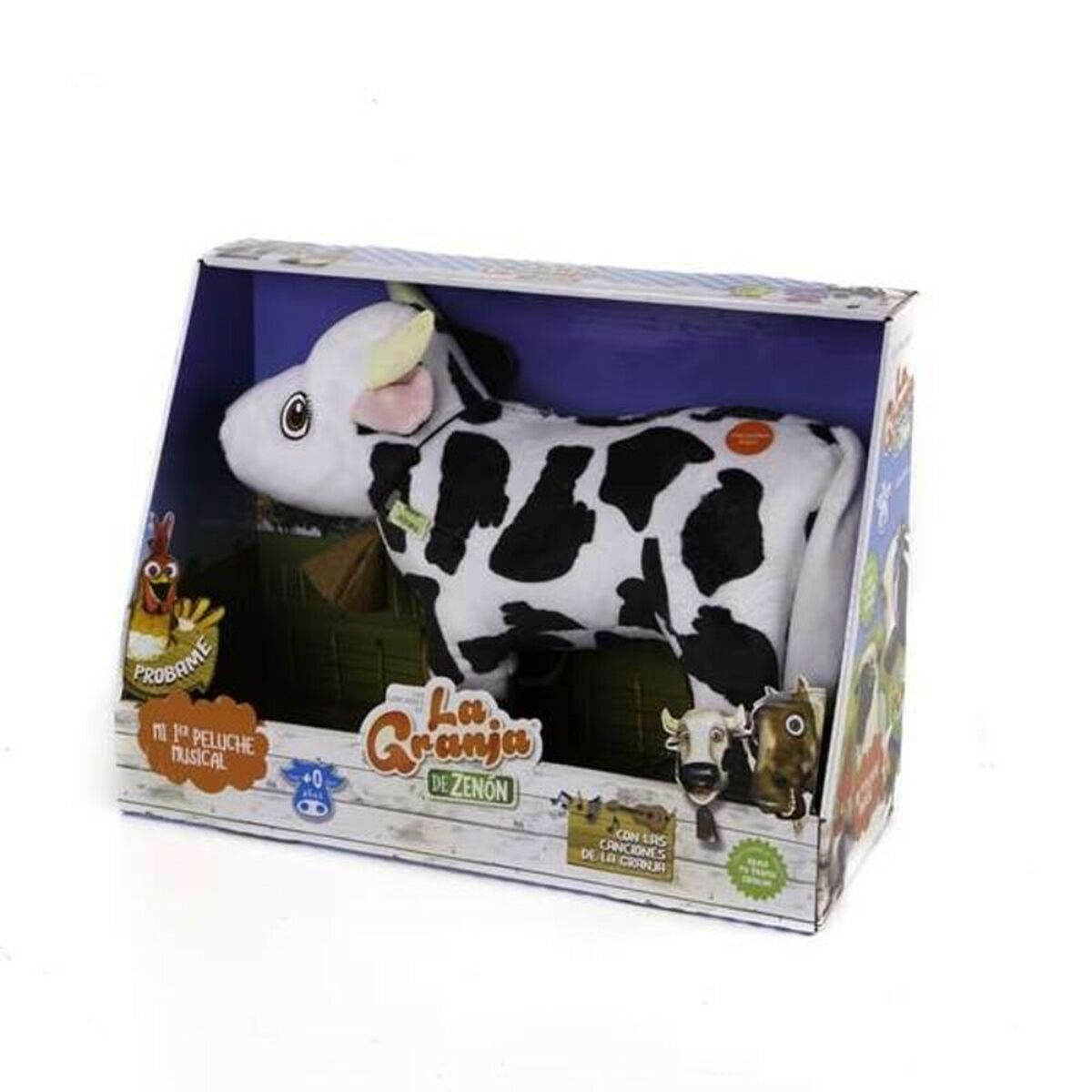 Un peluche de vaca en una caja. Es blanco y negro y la caja tiene texto e imágenes.