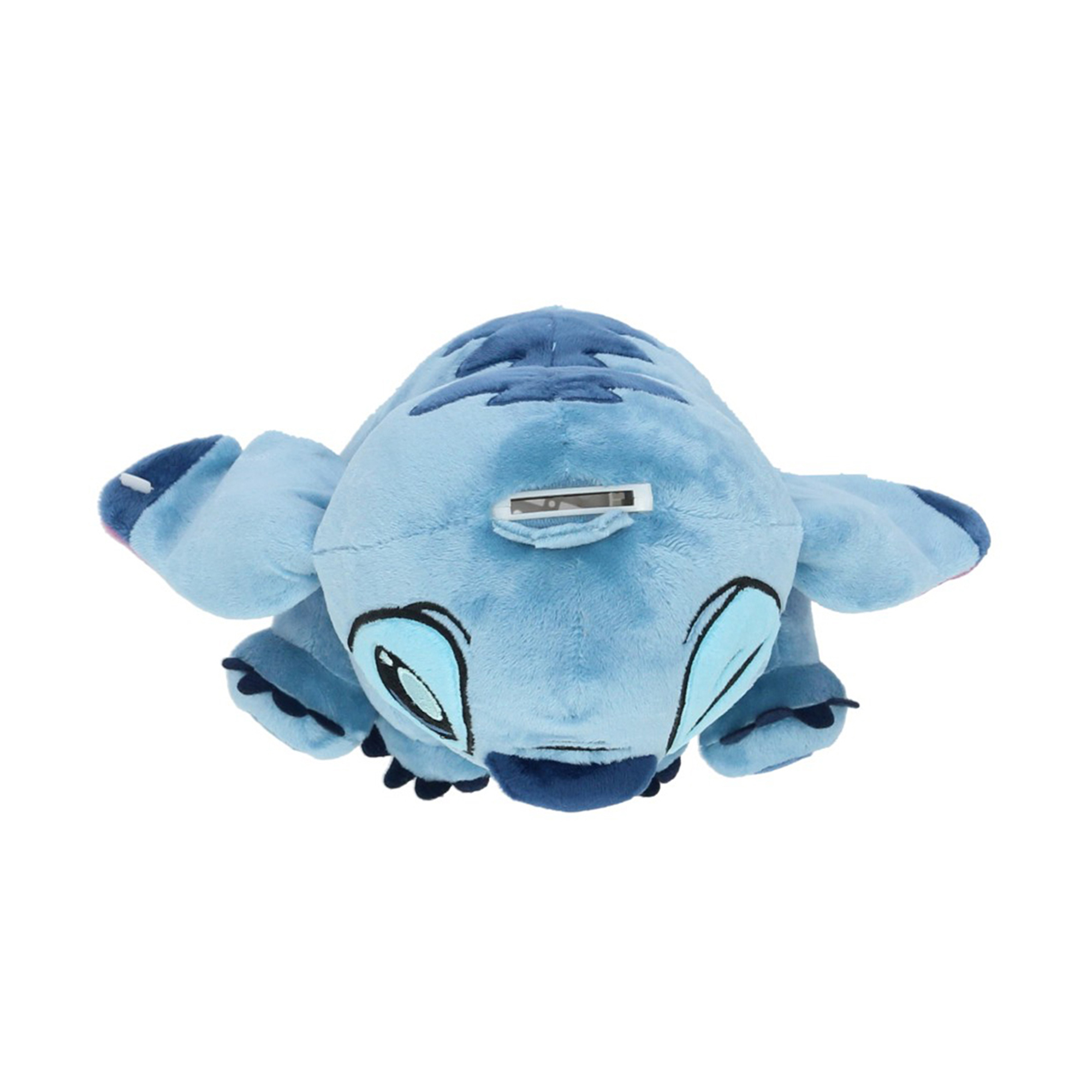 Un peluche di Stitch blu, sdraiato. Ha grandi occhi, grandi orecchie e una fessura sulla schiena. Lo sfondo è bianco.