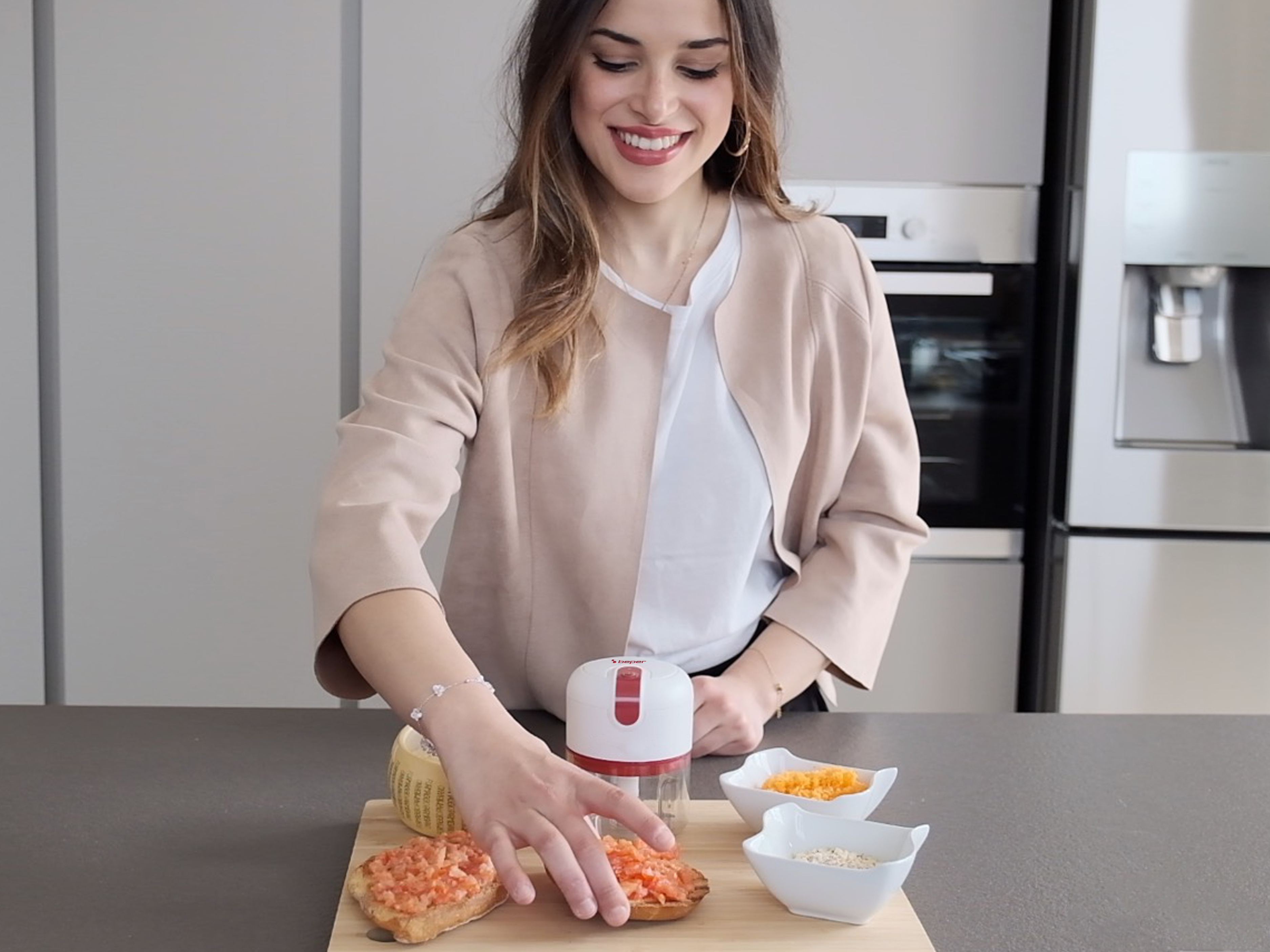Donna che prepara cibo con un tritatutto. Bruschetta, formaggio e verdure sul tavolo.