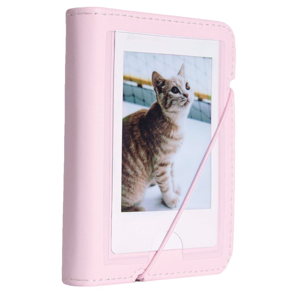 Kedi fotoğrafı olan pembe fotoğraf albümü. Kedi kahverengi ve beyaz, yukarı bakıyor. Albümün pembe bir lastiği var.