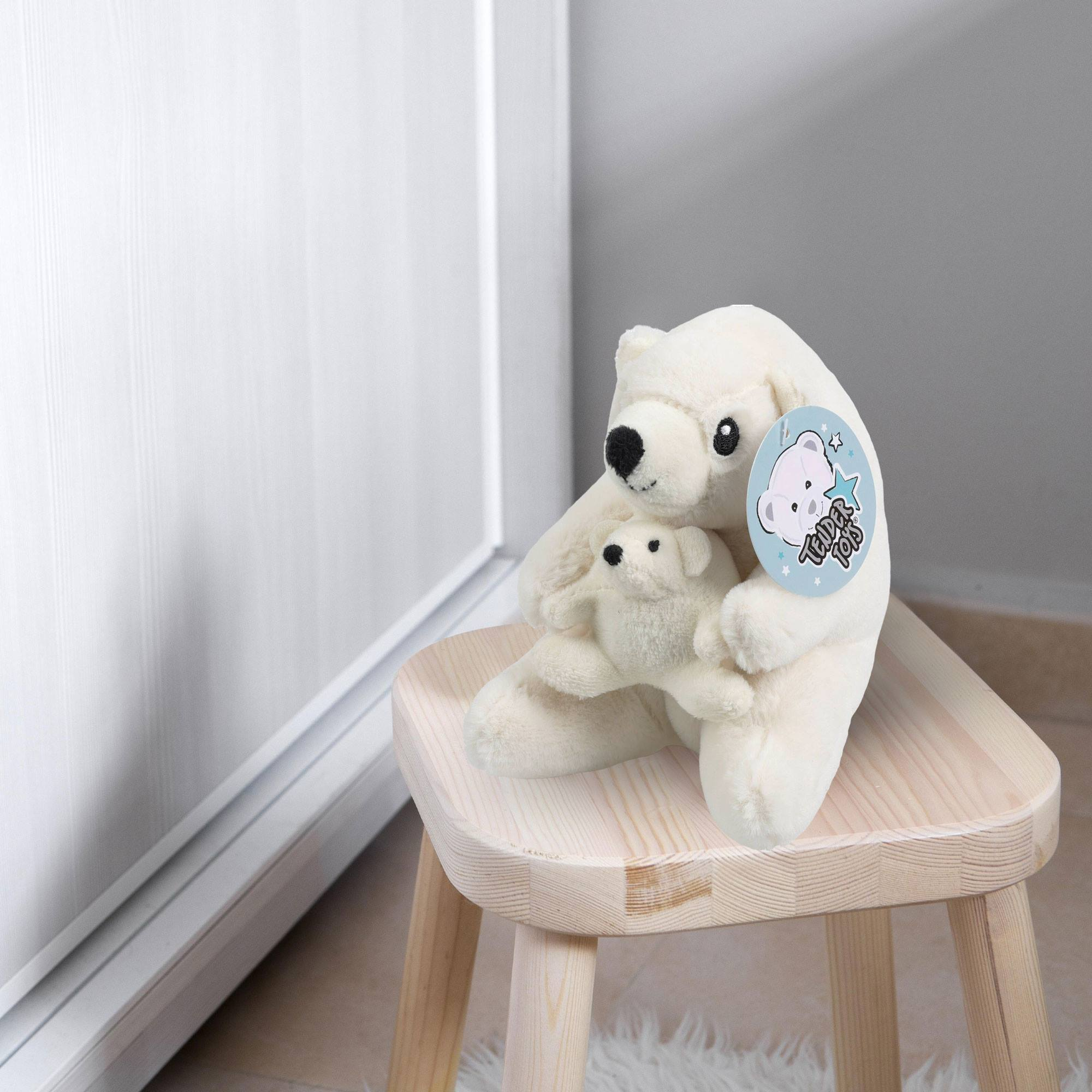 Un peluche de oso polar blanco, abrazando a un oso más pequeño, está sobre un taburete de madera. Una etiqueta de Tender Toys está adjunta.