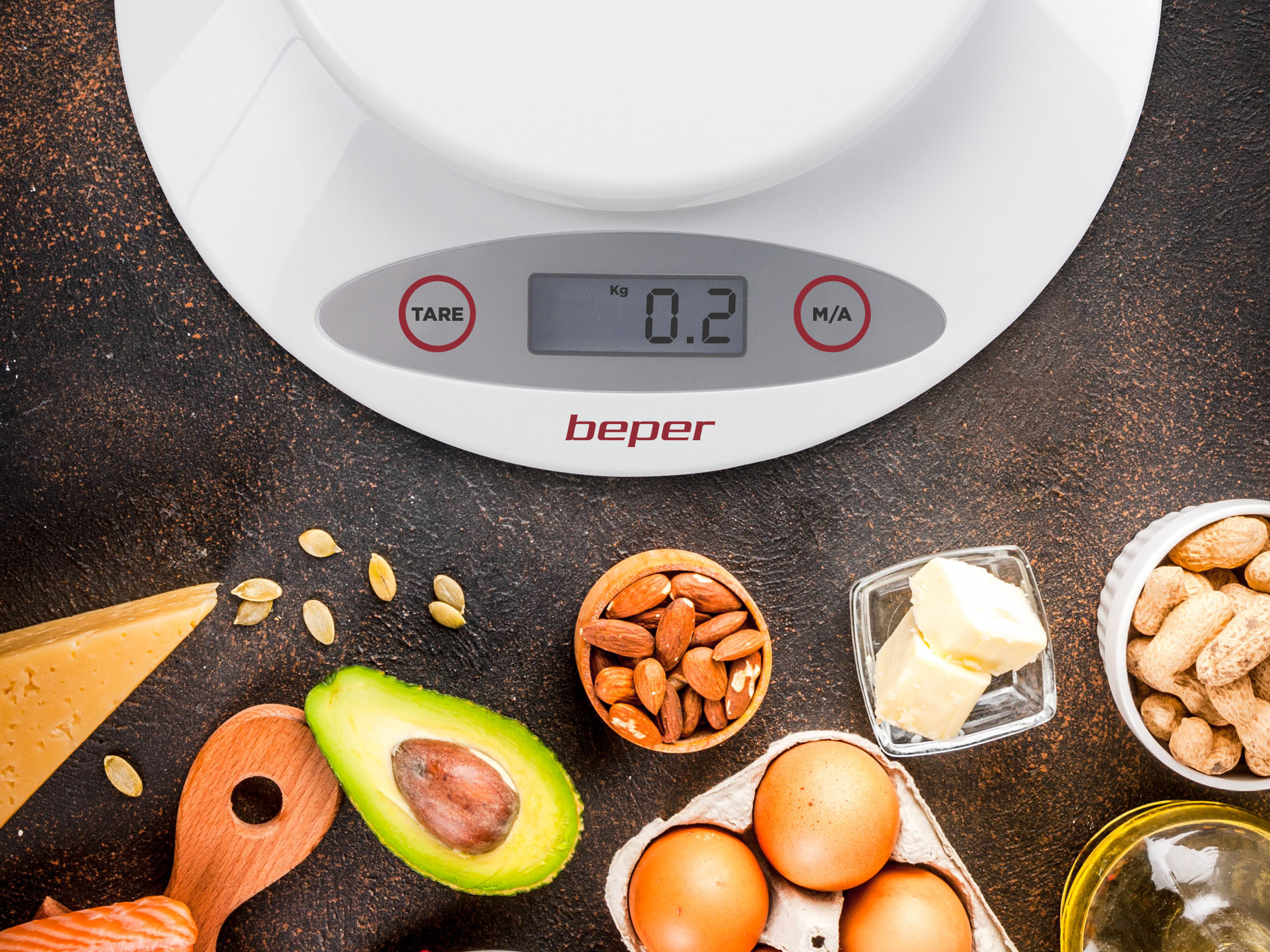 Una bilancia da cucina con 0,2 kg, circondata da ingredienti: avocado, mandorle, uova, formaggio, arachidi.