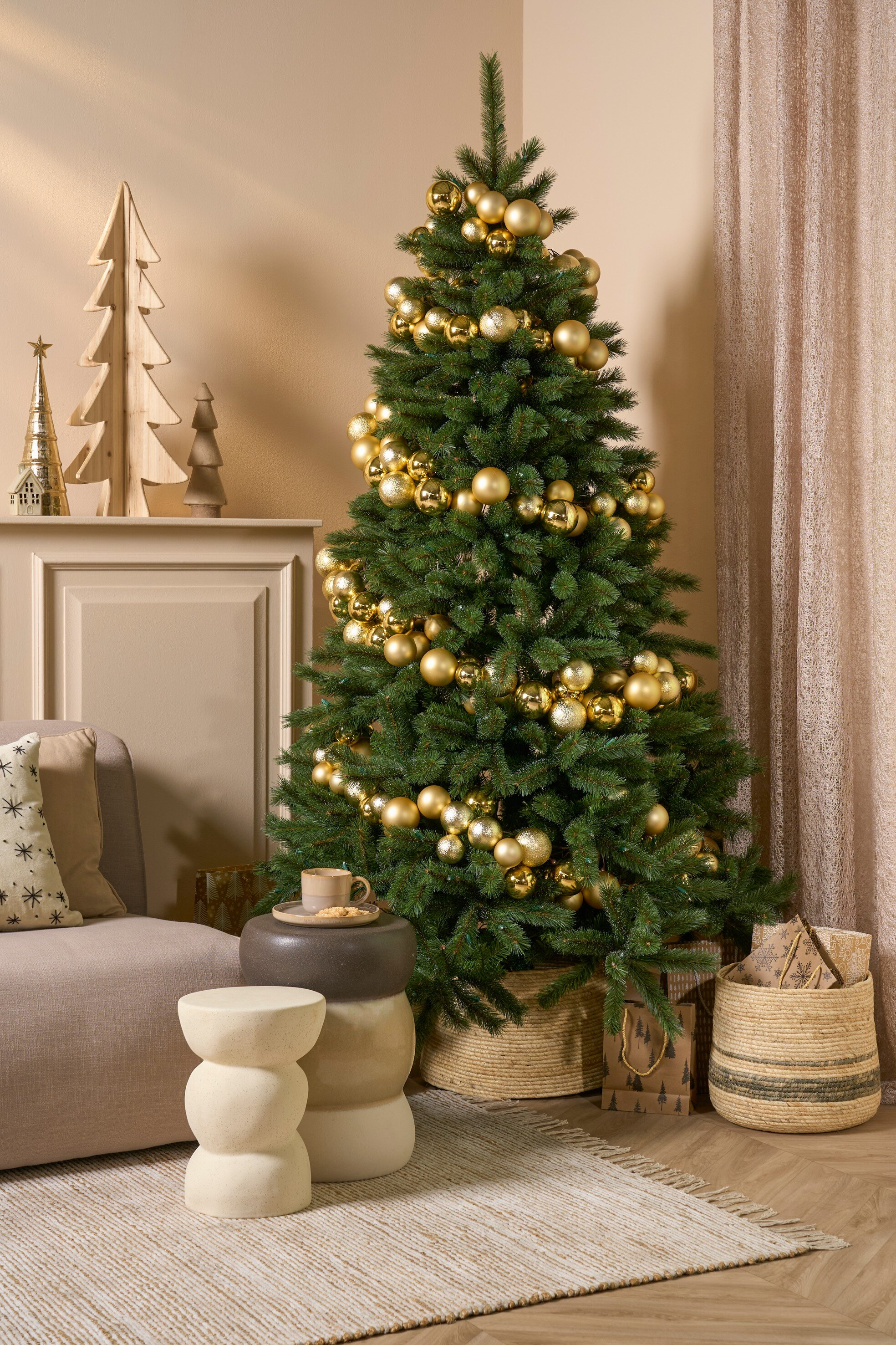 Un sapin de Noël décoré d'ornements dorés et d'autres décorations de vacances dans une pièce.