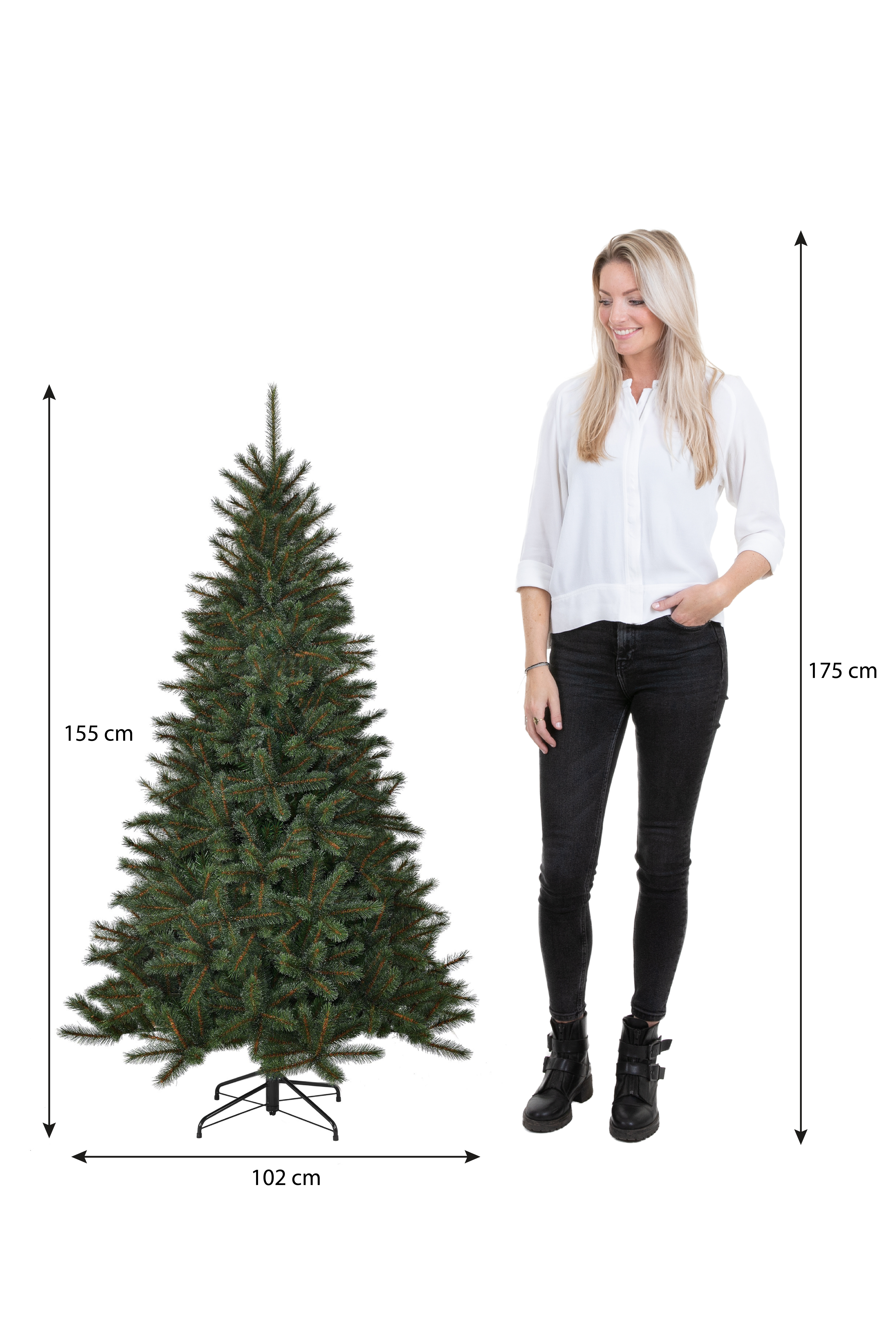 Une femme se tient à côté d'un sapin de Noël artificiel. Les mesures sont affichées. La femme porte un pantalon noir et une chemise blanche.