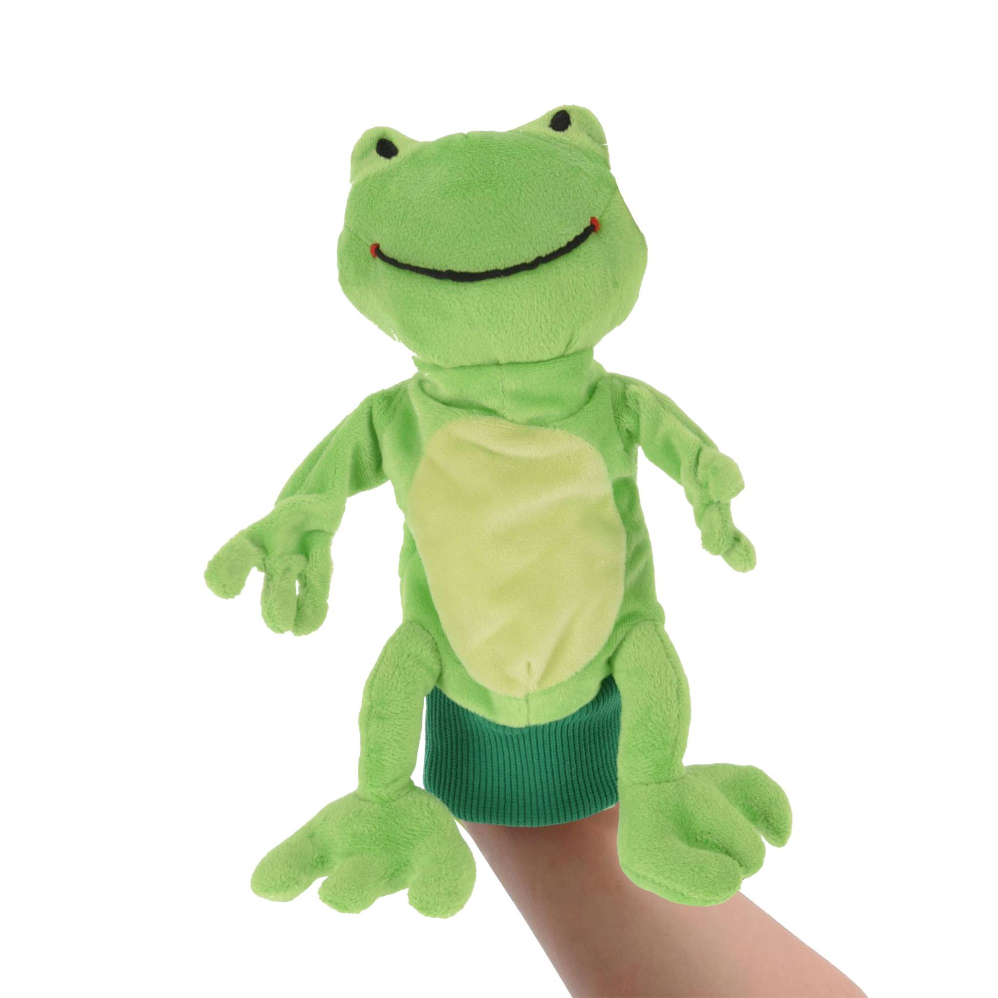Una marioneta de rana verde con vientre verde claro es sostenida por una mano. Tiene una cara sonriente y ojos negros.