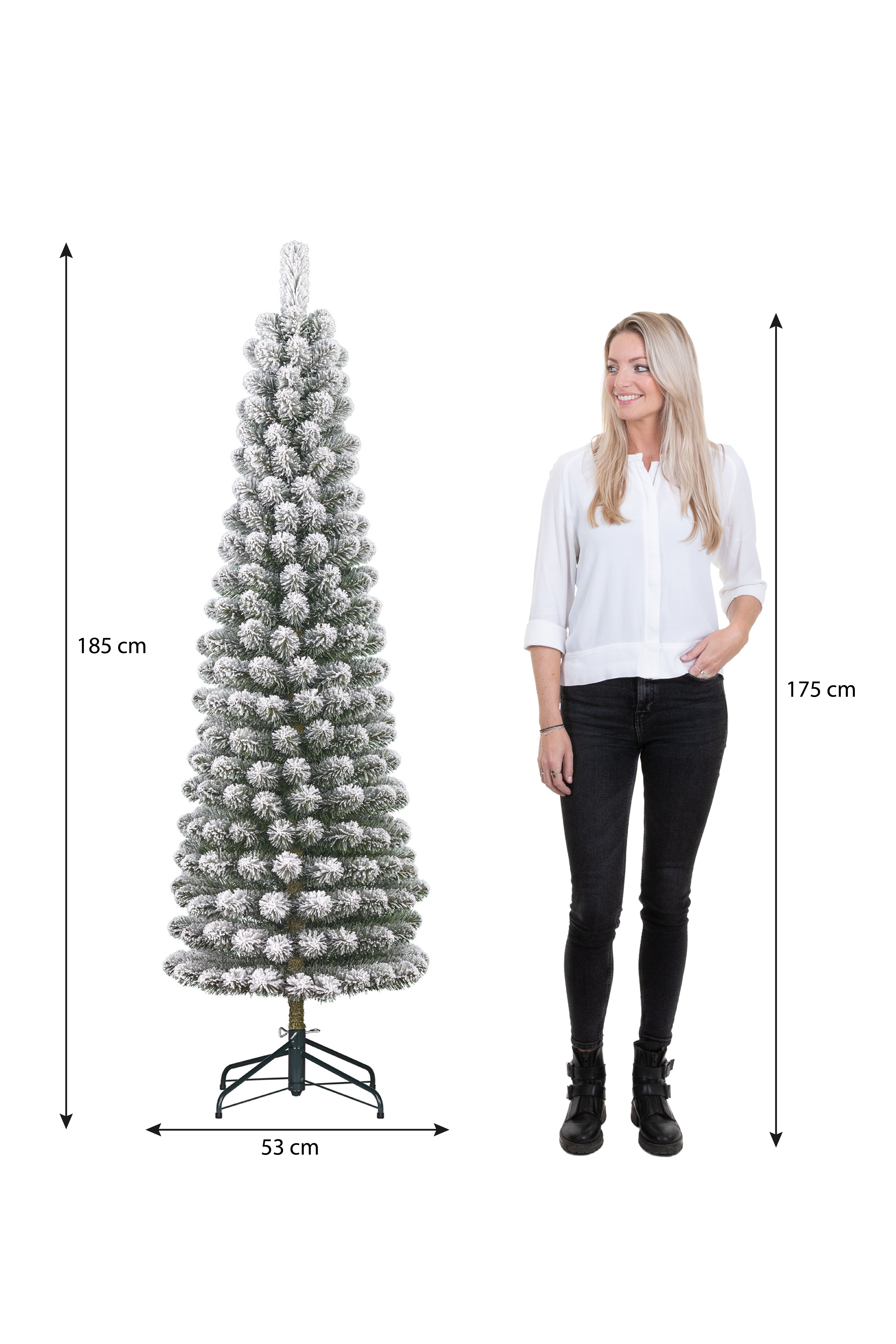 Une femme se tient à côté d'un sapin de Noël enneigé. L'arbre mesure 185 cm de haut, la femme 175 cm. L'arbre fait 53 cm de large.