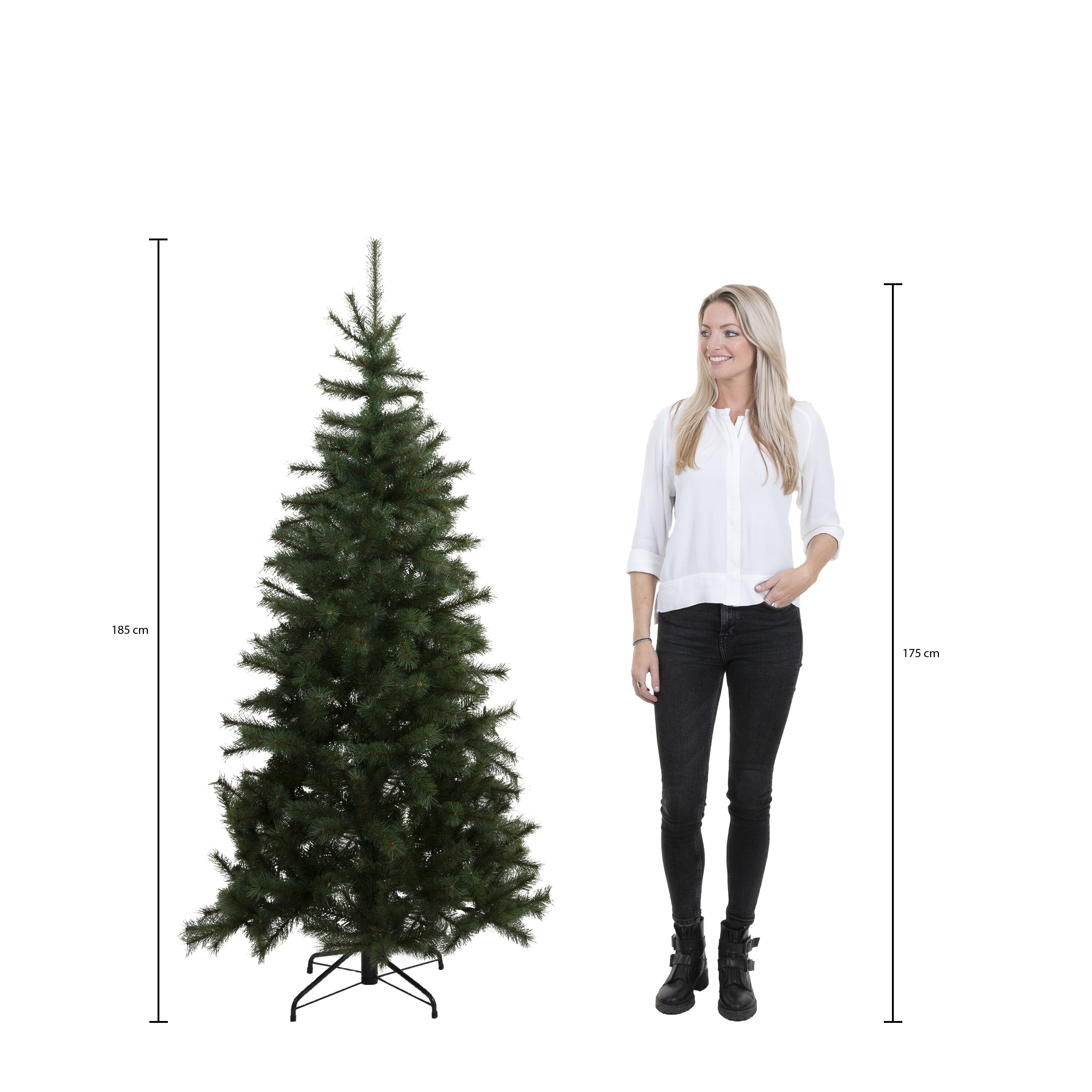 Une femme se tient près d'un sapin de Noël vert. Les mesures des deux sont indiquées. La femme sourit.