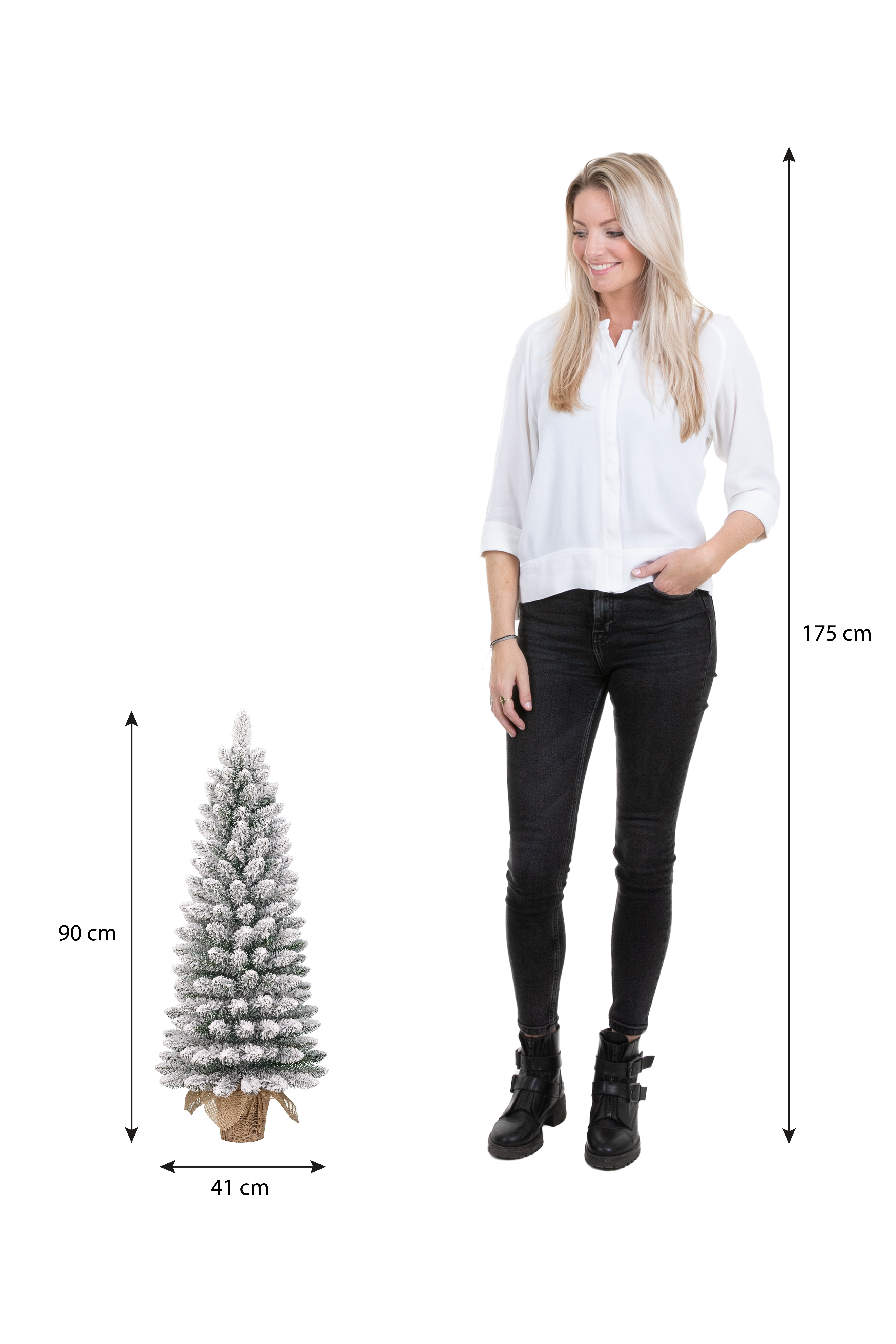 Une femme se tient près d'un petit sapin de Noël. L'arbre mesure 90 cm de haut. La femme mesure 175 cm.