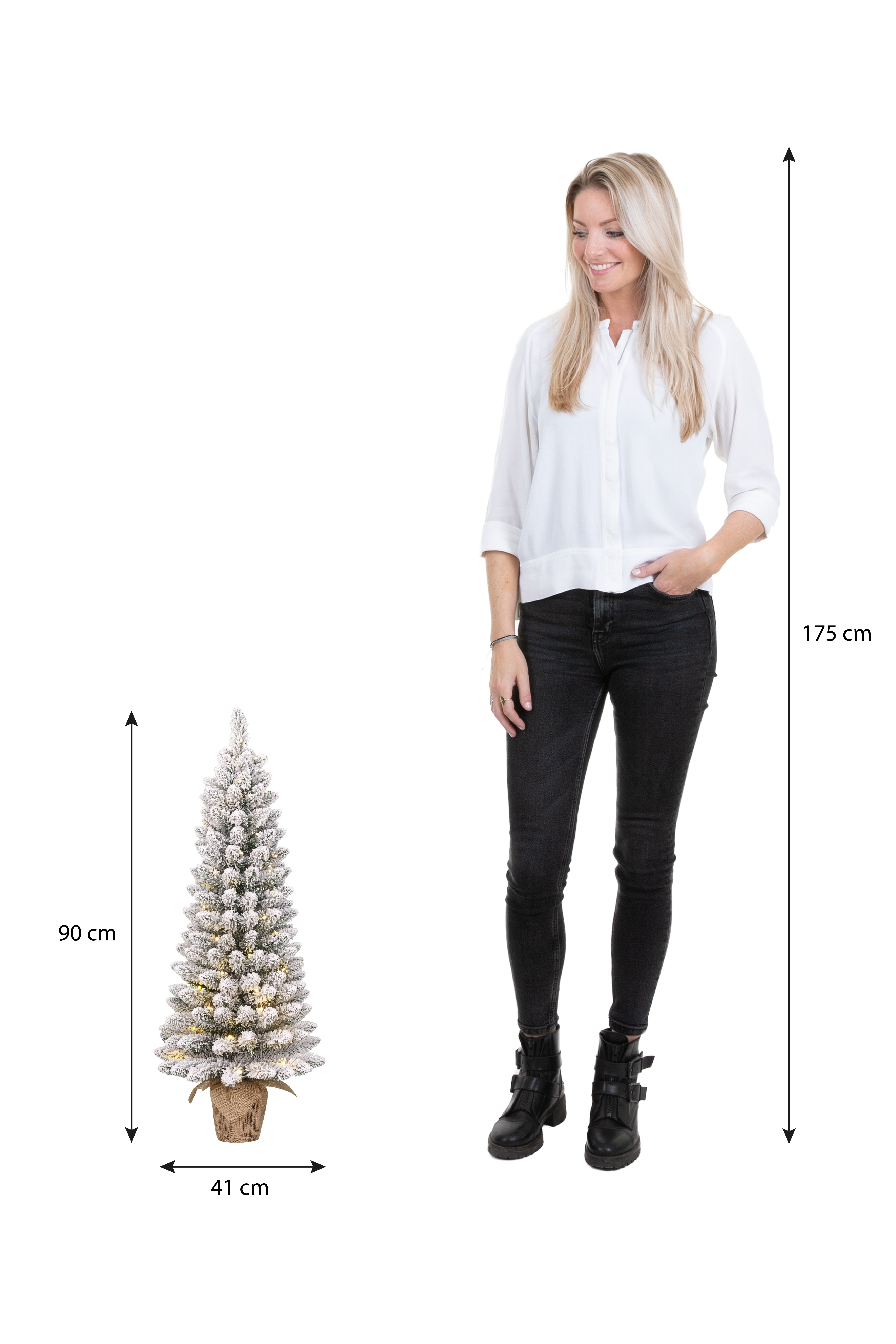 Une femme se tient près d'un petit sapin de Noël. L'arbre mesure 90 cm de haut. La femme mesure 175 cm.