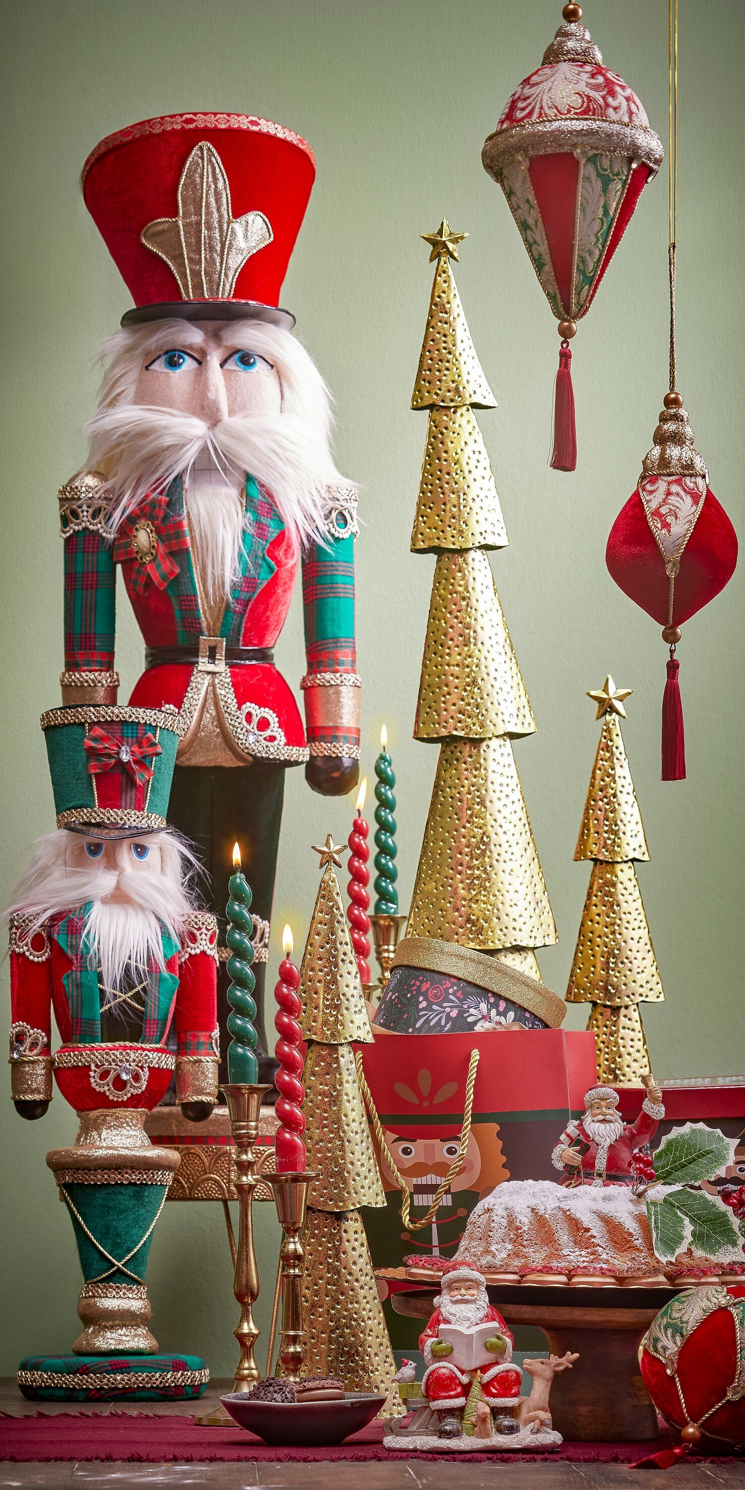 Christmas decorations: nutcrackers, golden trees, hanging ornaments, candles, Santa figurines, and a cake, all in a festive scene.