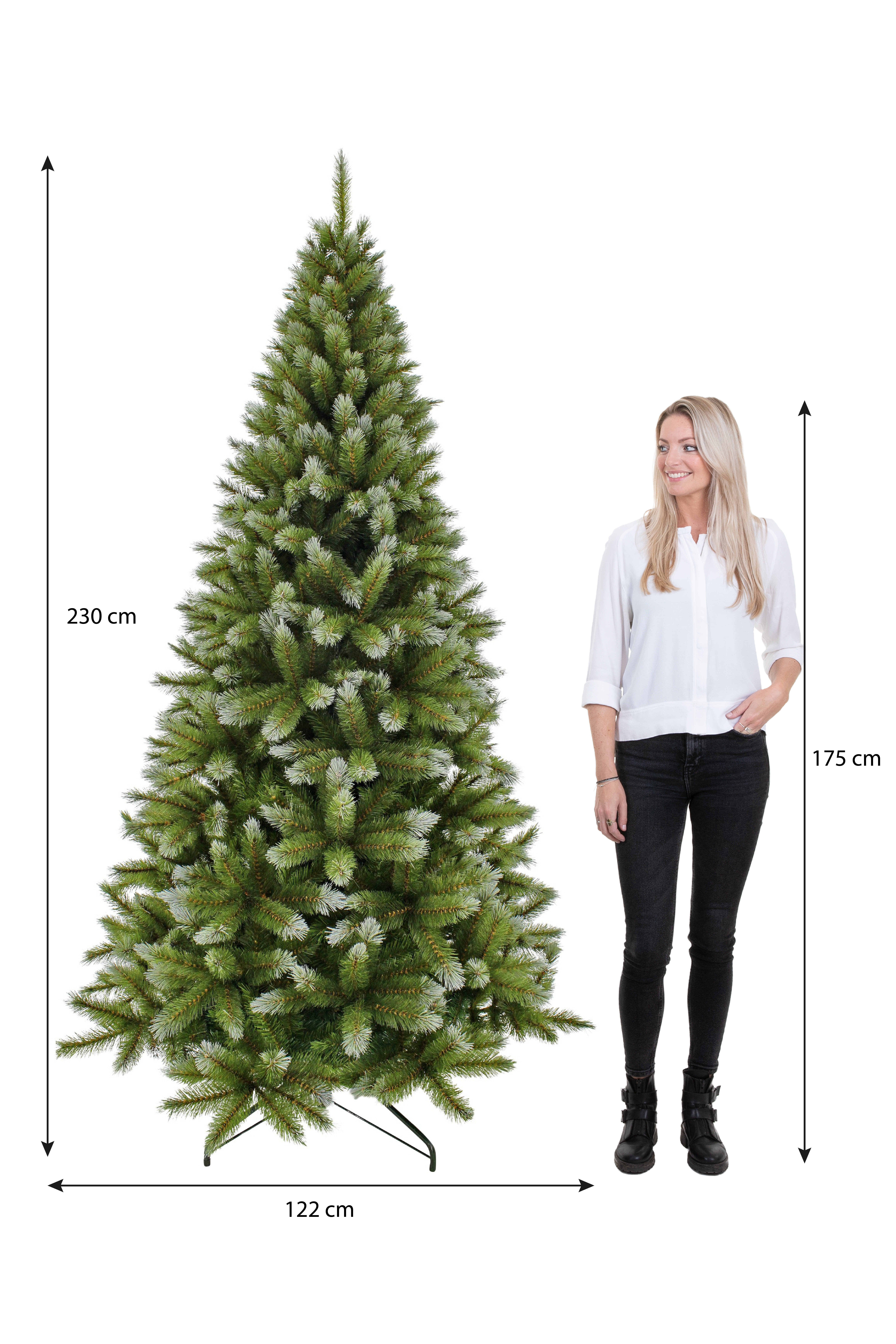 Une femme se tient près d'un sapin de Noël vert. L'arbre mesure 230 cm de haut et 122 cm de large. La femme mesure 175 cm de haut.